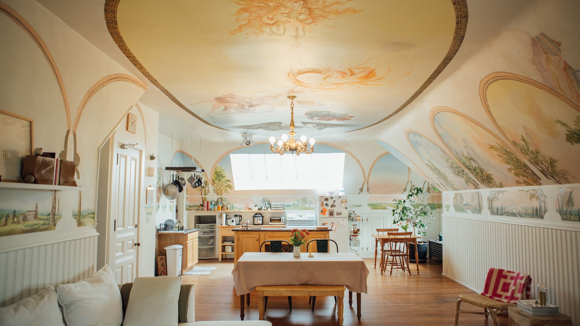 A photo of an apartment with murals of angels painted on the walls.