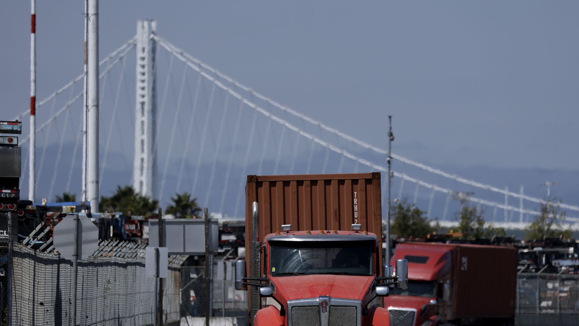 A red truck driving past a bridge