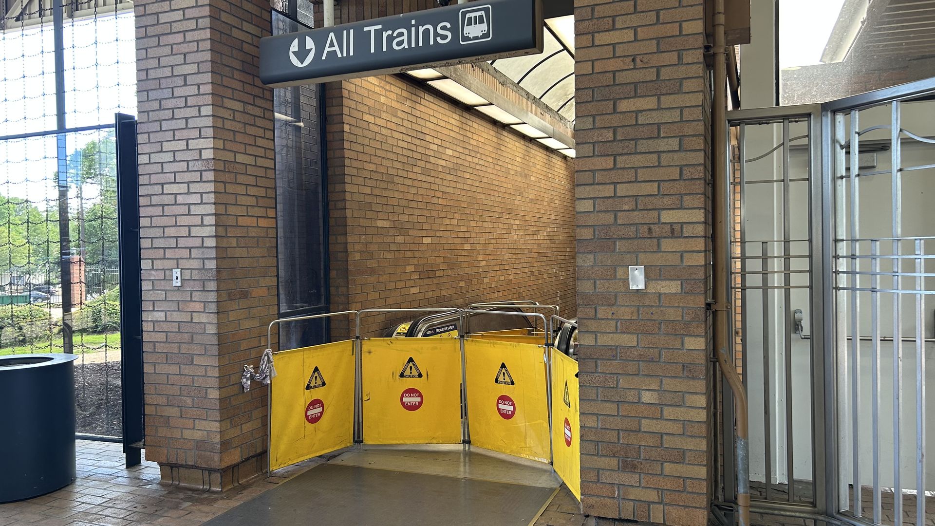 A photograph of a barricaded escalator needing repairs