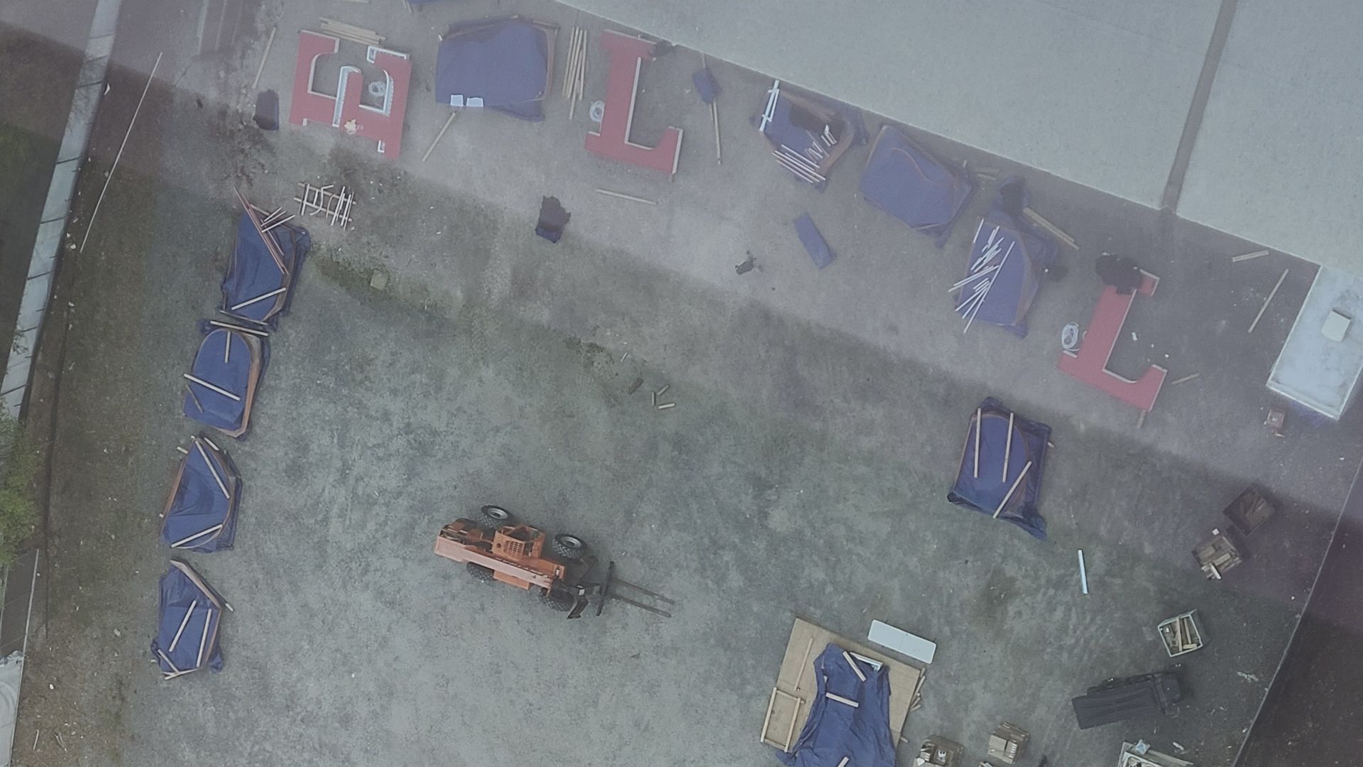 Giant letters that read out Wells Fargo sprawled on ground, some of them are covered in blue tarp