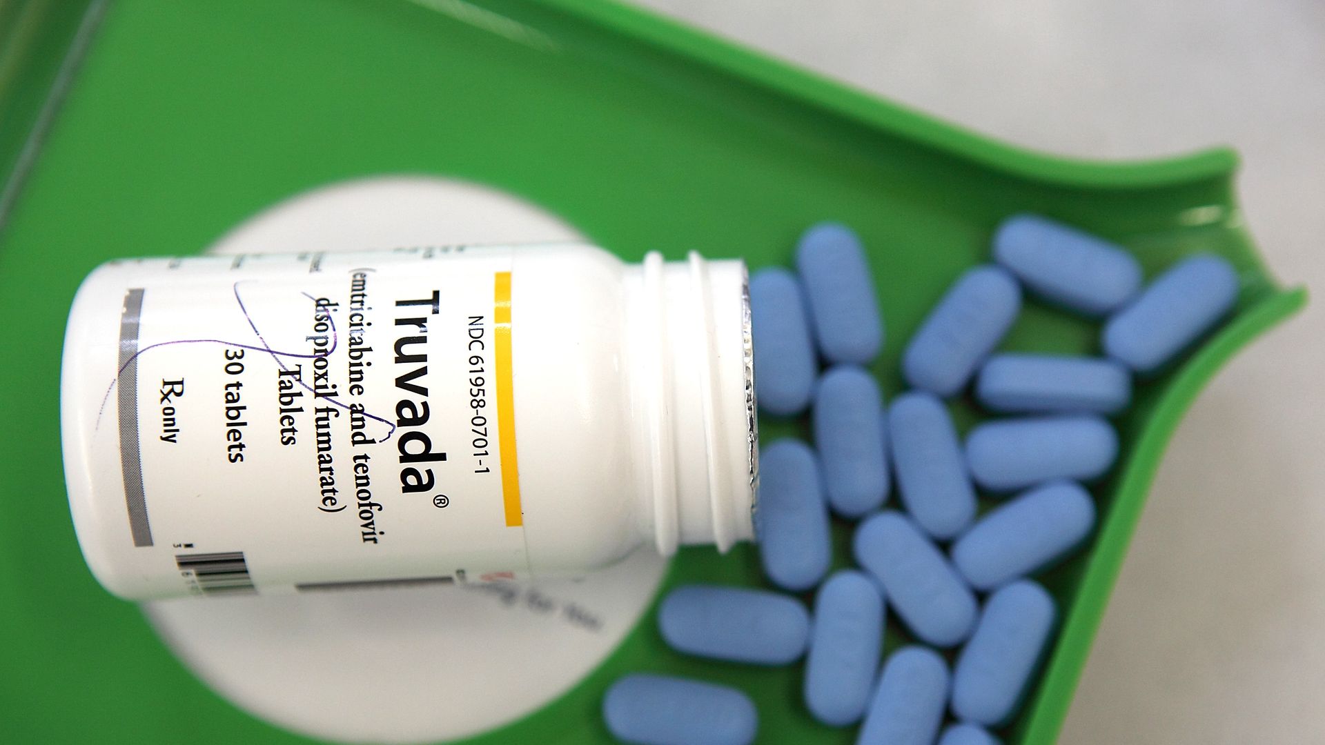 A bottle of Truvada with pills coming out of it.
