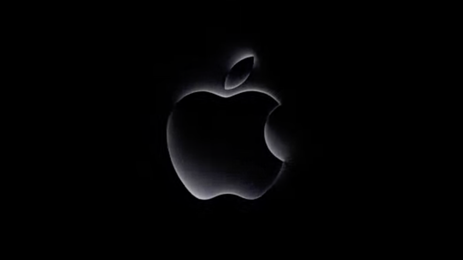 A grey metallic Apple logo against a black background