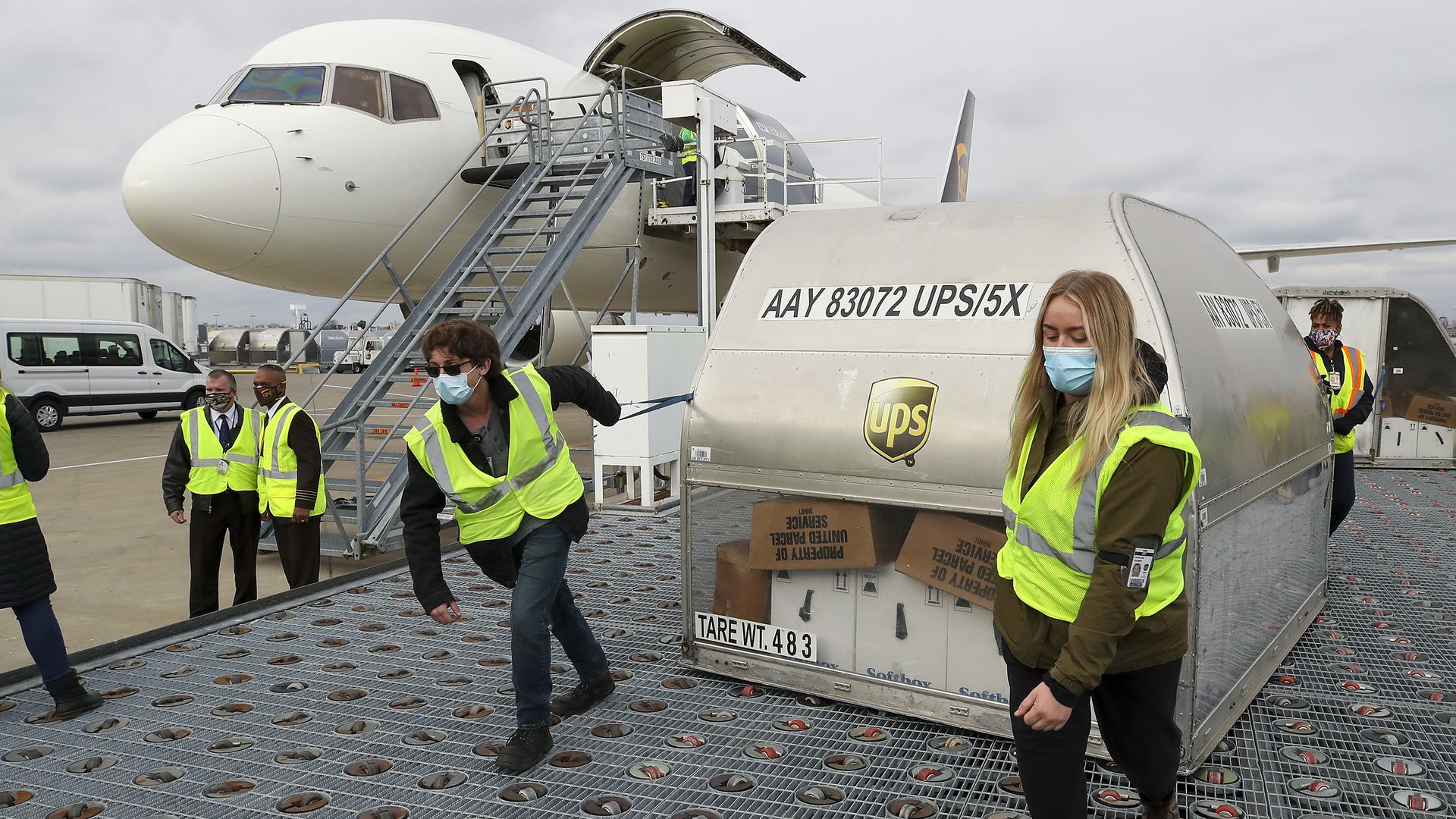 Workers move a large package of coronavirus vaccines