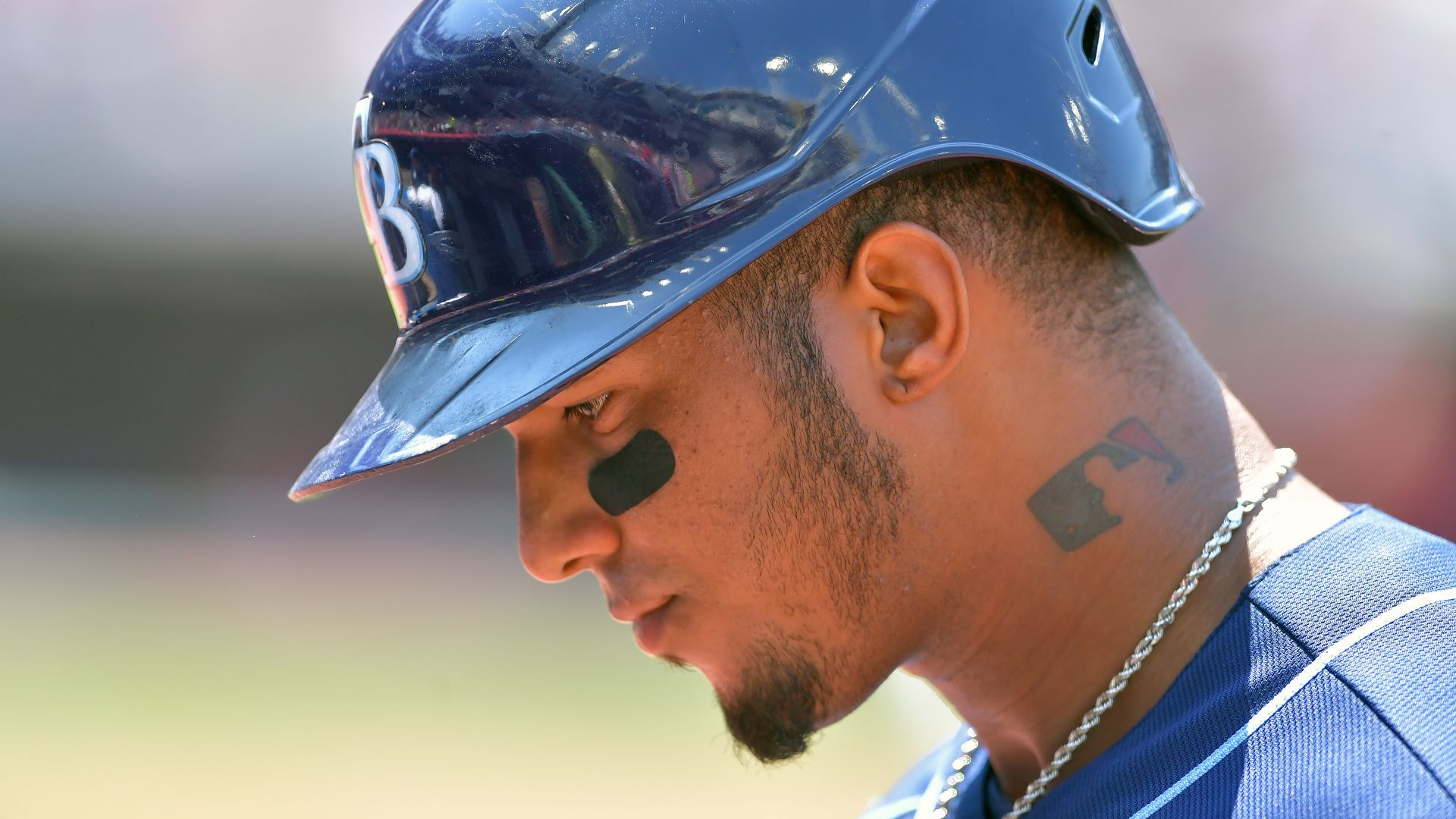 a A profile shot of Wander Franco #5 of the Tampa Bay Rays. An MLB logo tattoo is visible on the side of his neck