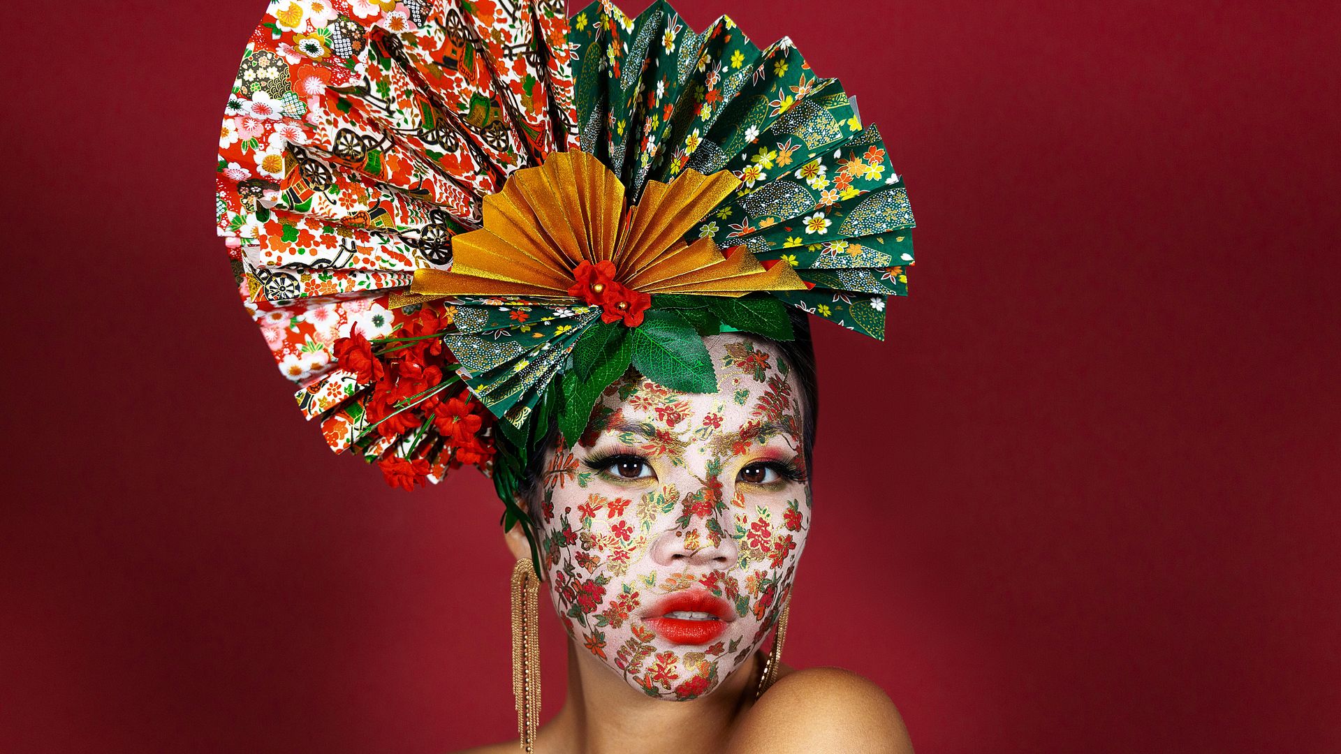 Photo of a woman with roses drawn on her face wearing a fan-shaped hat