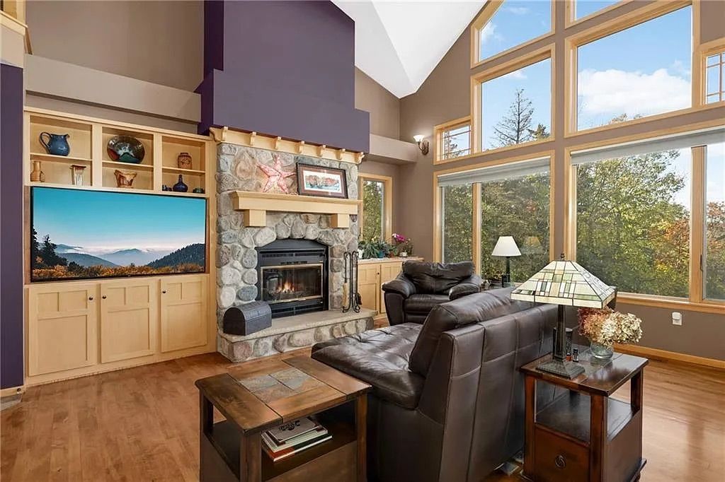 A living room with large windows showing a river.