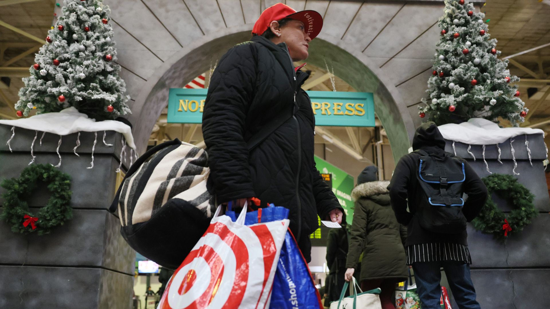 Shopper wearing coat and red cap holding Target shopping bag