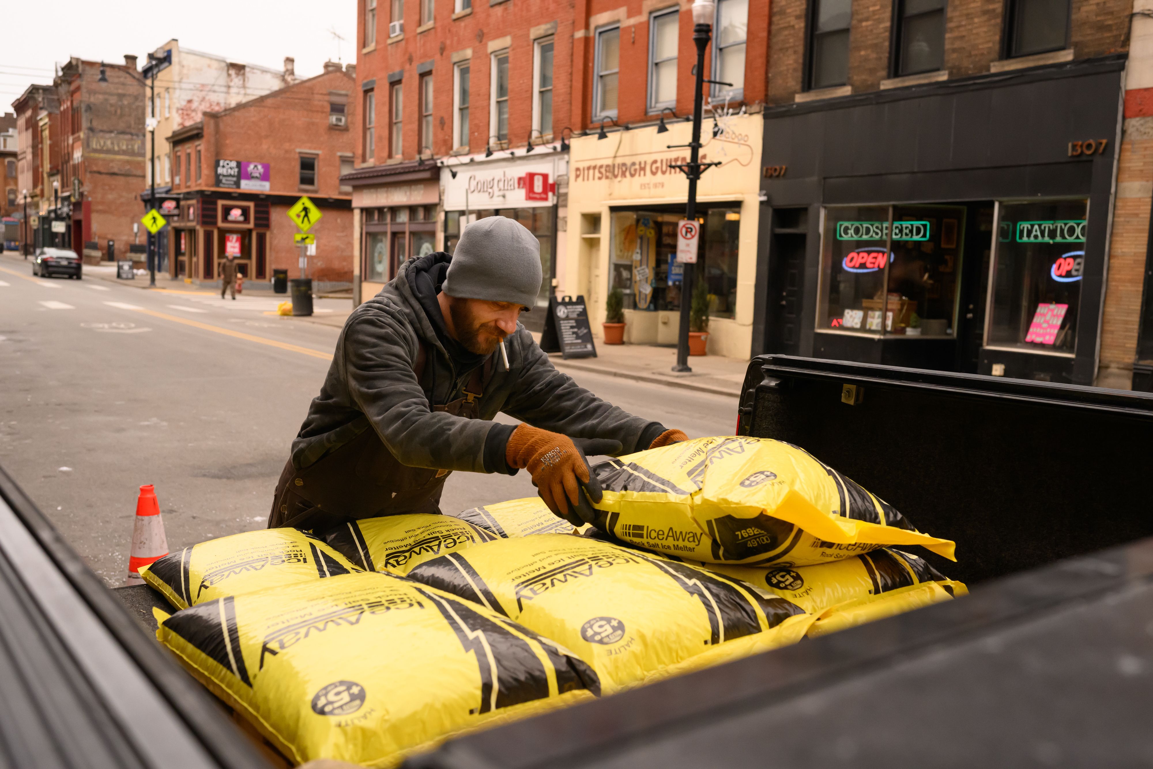 A worker in Pittsburgh stacks rock salt for sale in the back of a pick-up truck ahead of an anticipated winter storm