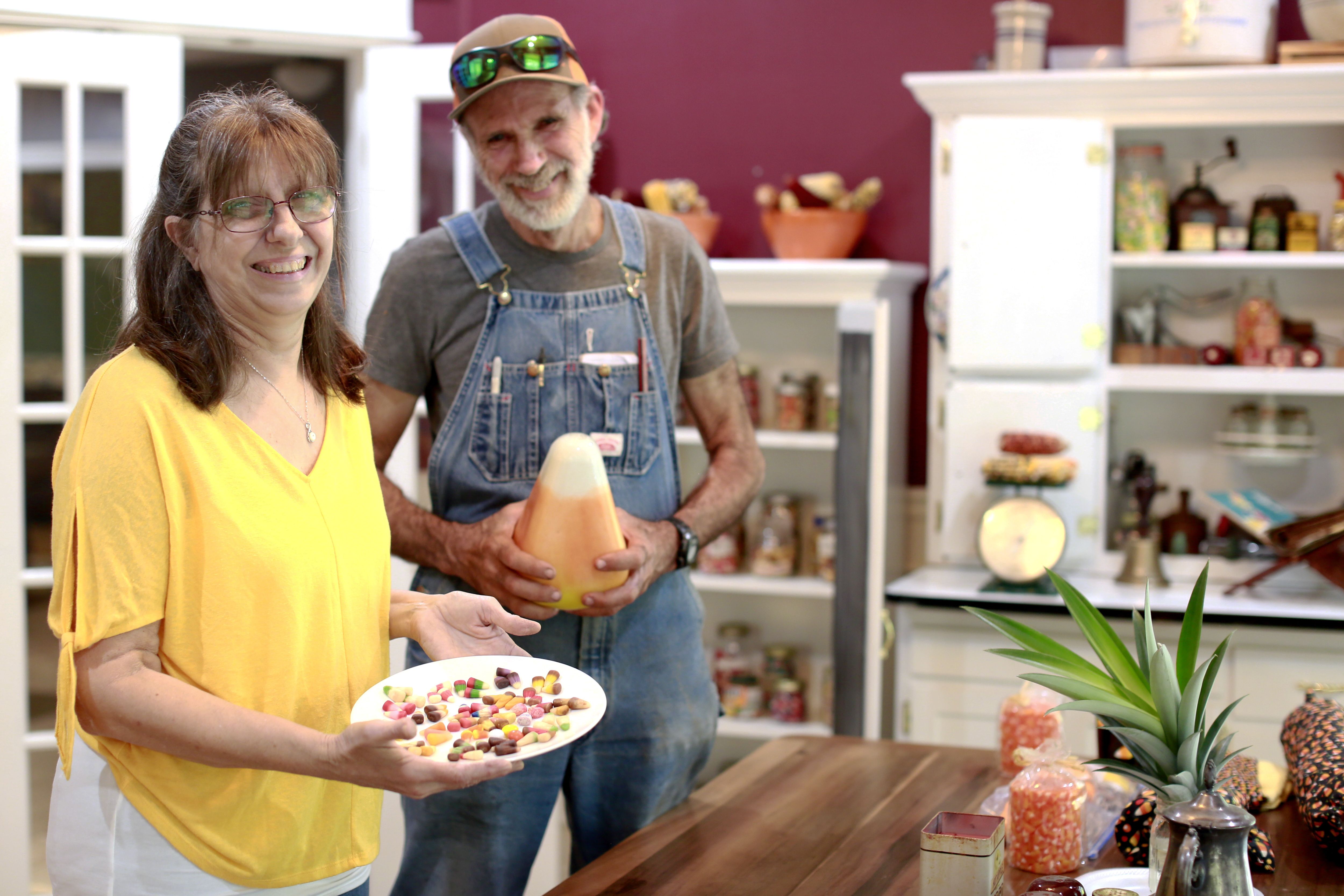 Wanda King, left, displays nearly 40 varieties of Candy Corn as her husband, Danny King, holds a Candy corn-inspired lamp at their home near Wiggins, Miss., on Oct. 7, 2023. One woman in Mississippi has amassed a sizable collection. Another in Maine has built a wardrobe around it. Candy corn, one of the most divisive treats on the market, has proved it has staying power.