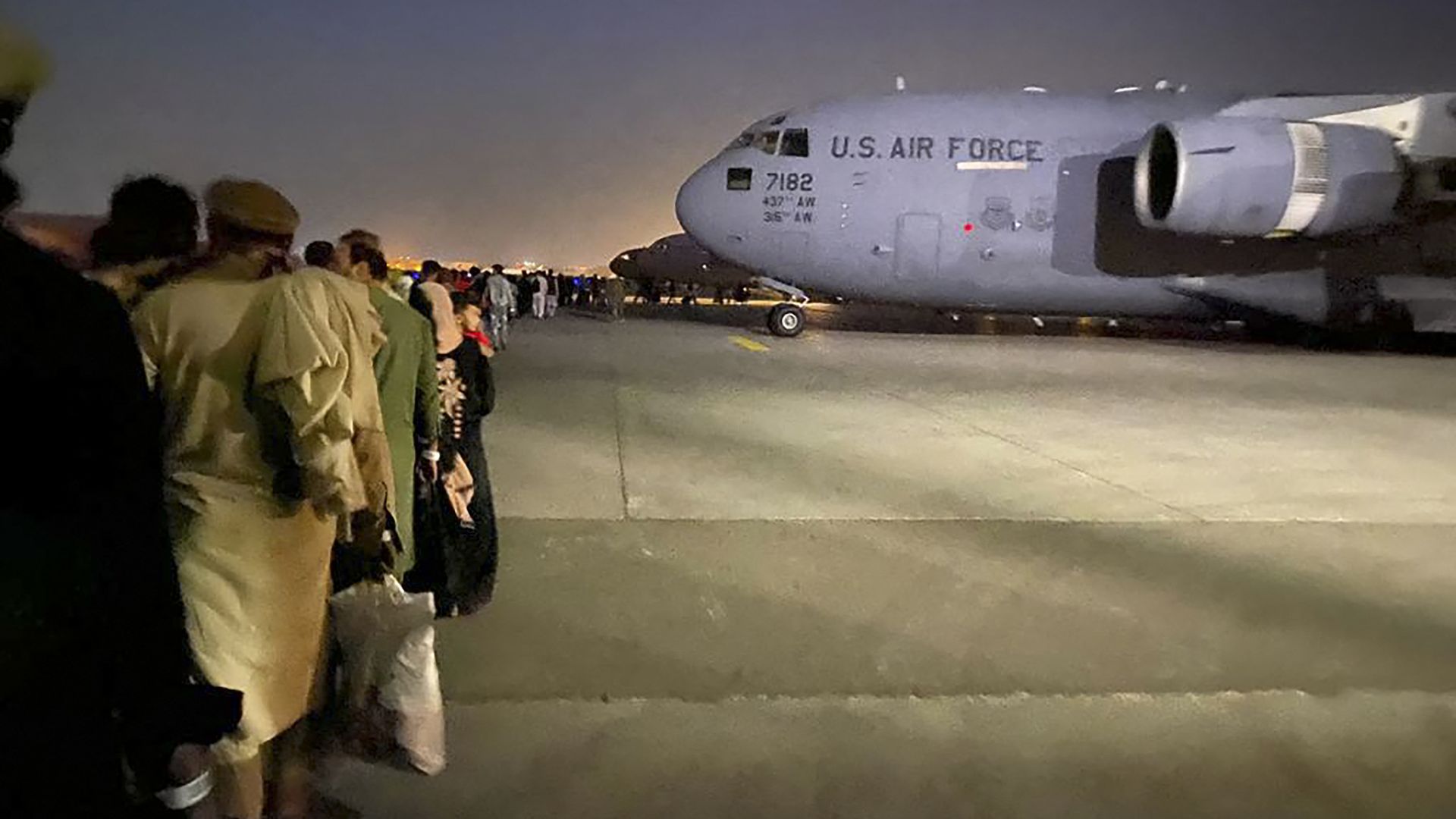 Afghan people queue up and board a U S military aircraft
