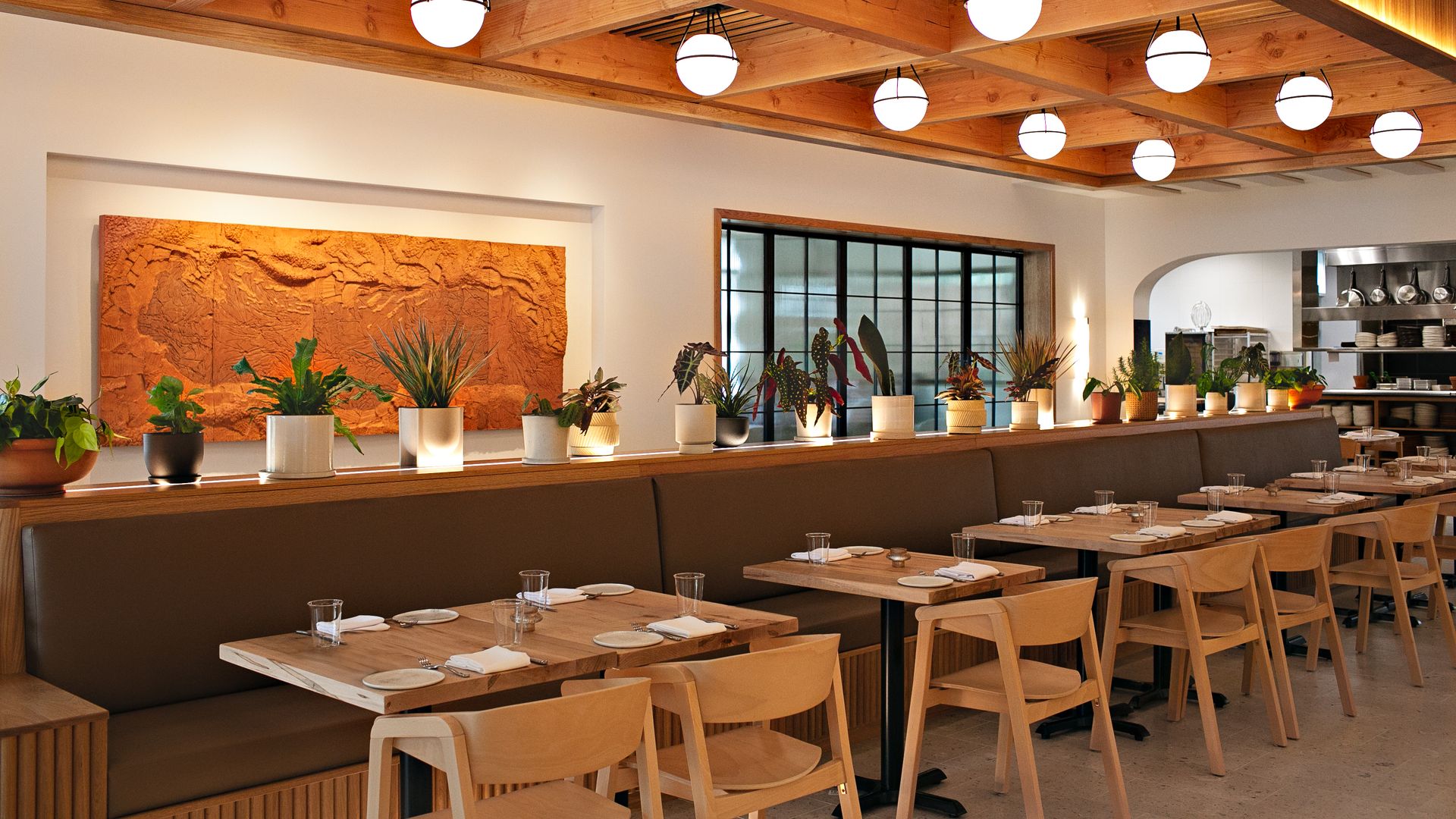 A dining room of a restaurant with tables along a wall