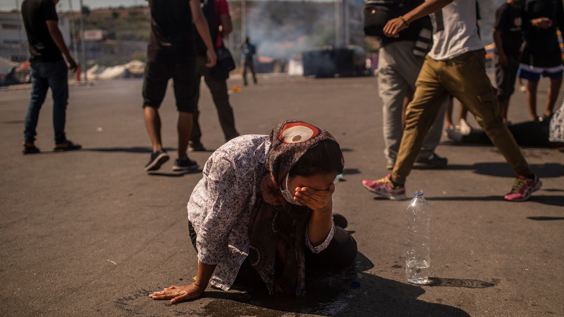 A woman cleans her eyes with water after police threw tear gas during clashes near the city Mytilene on the Greek island of Lesbos, on September 12