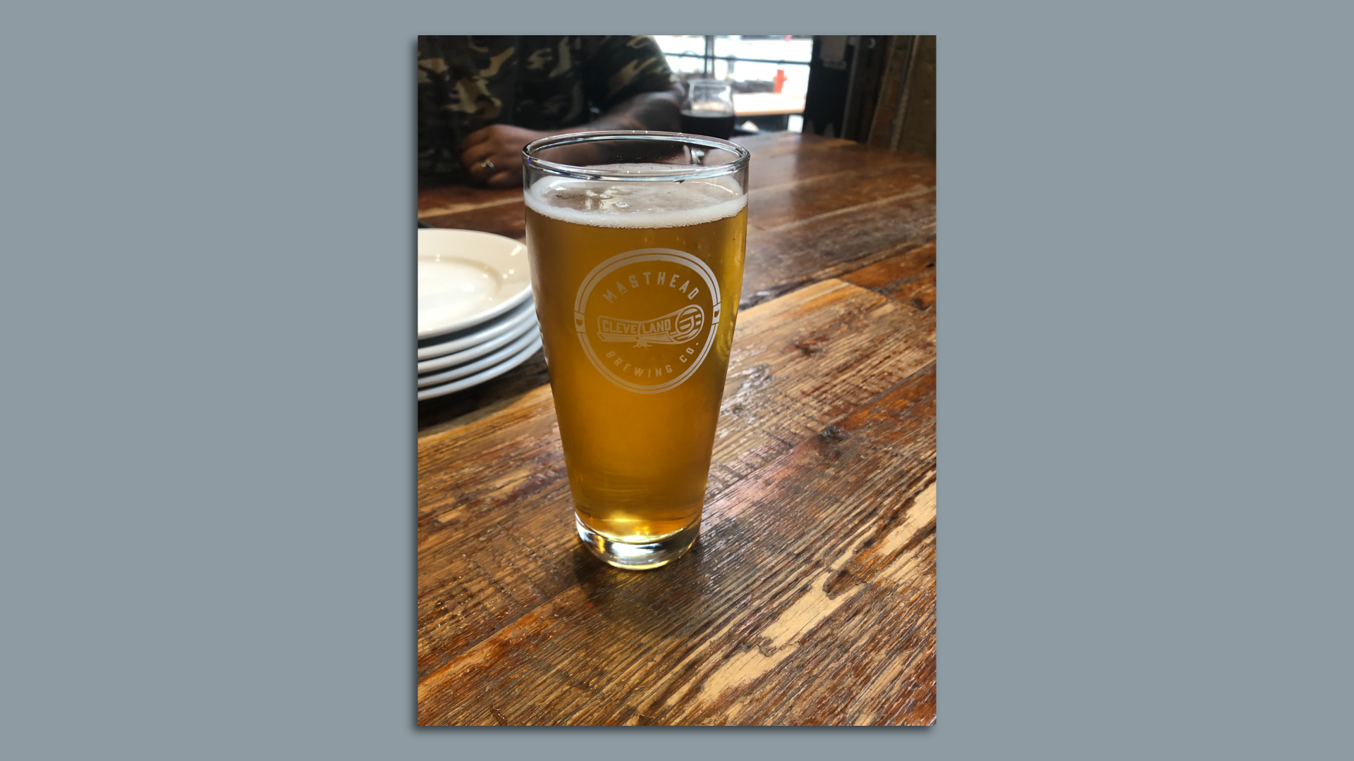 An image of a draft beer in a Masthead Brewing glass on a wooden table