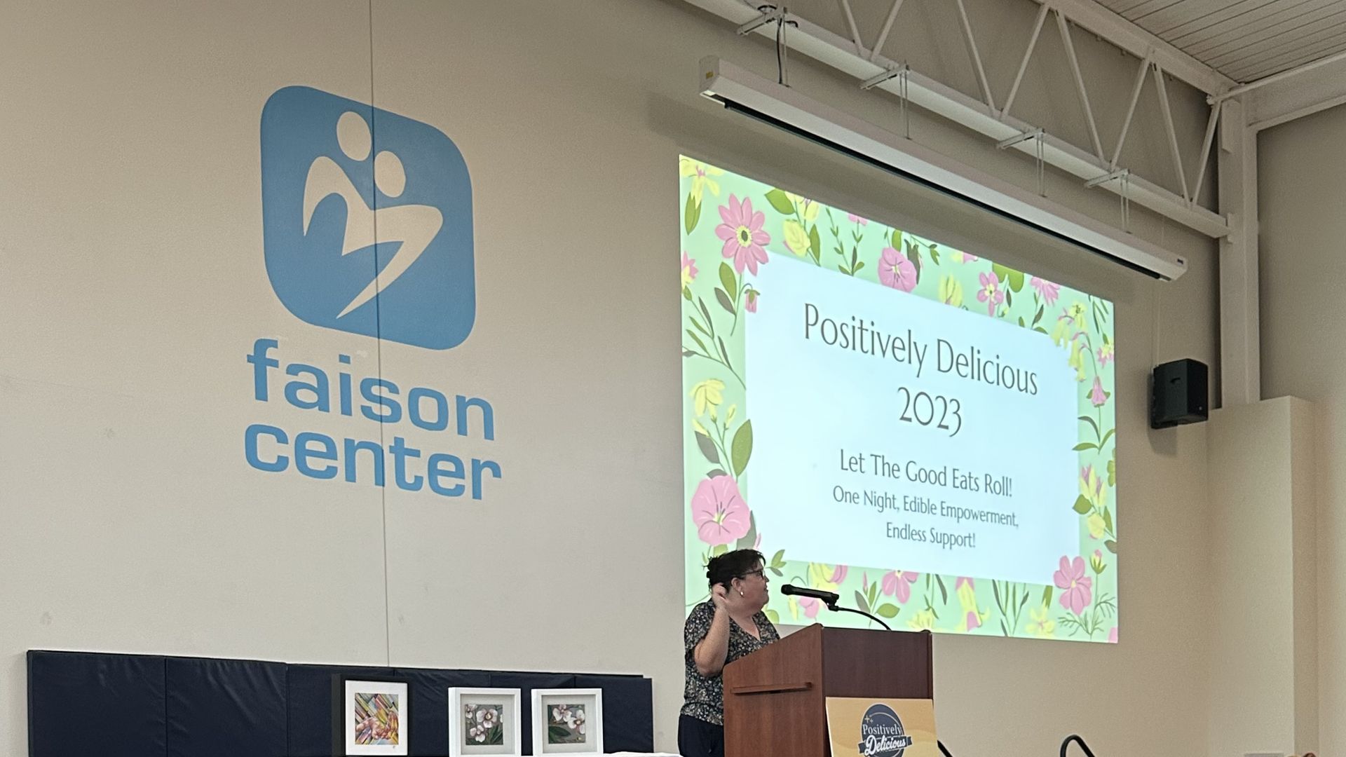 A woman stands on stage speaking