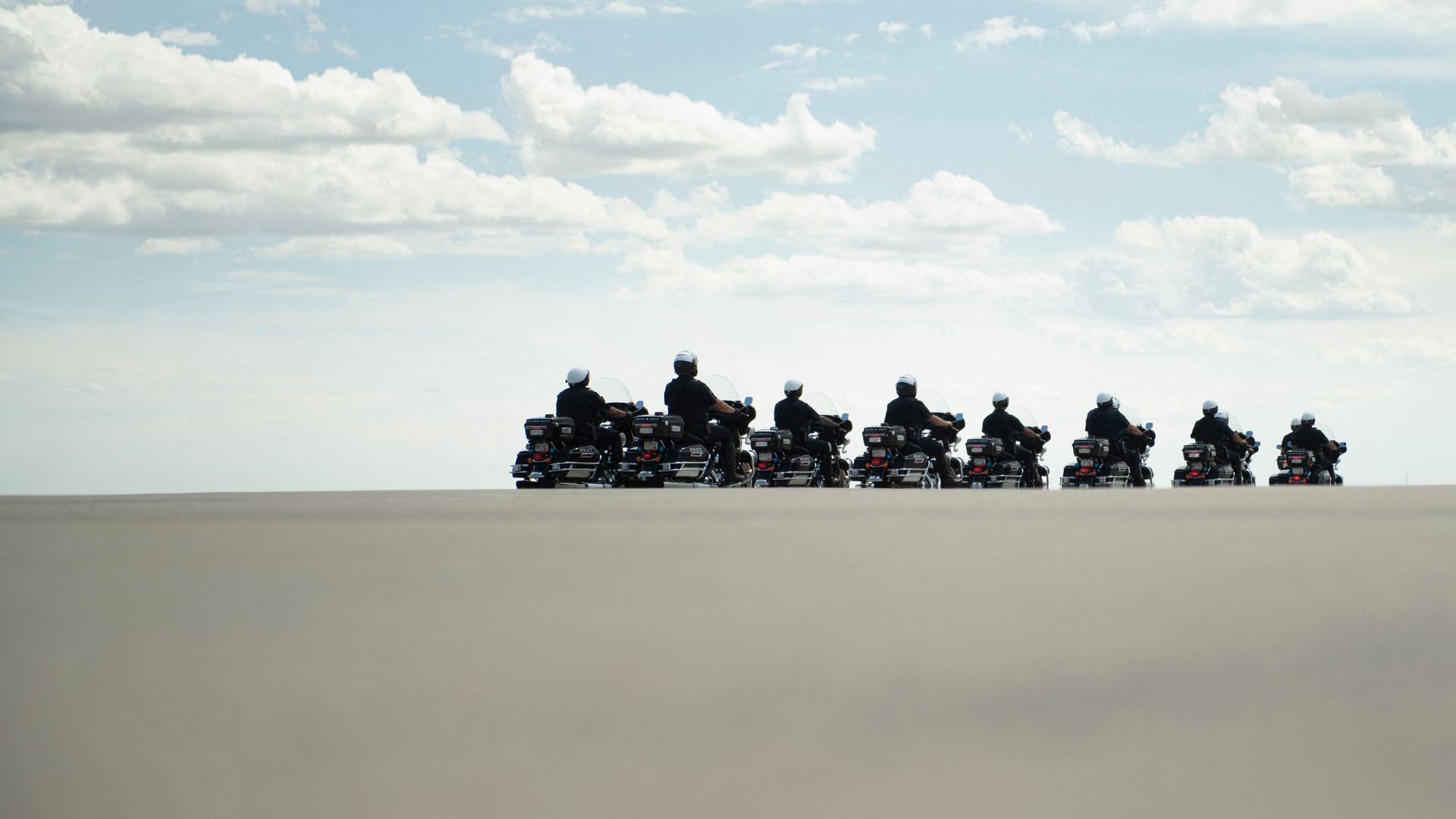 Police officers are seen sitting on motorcycles before escorting President Biden away from Denver's airport.