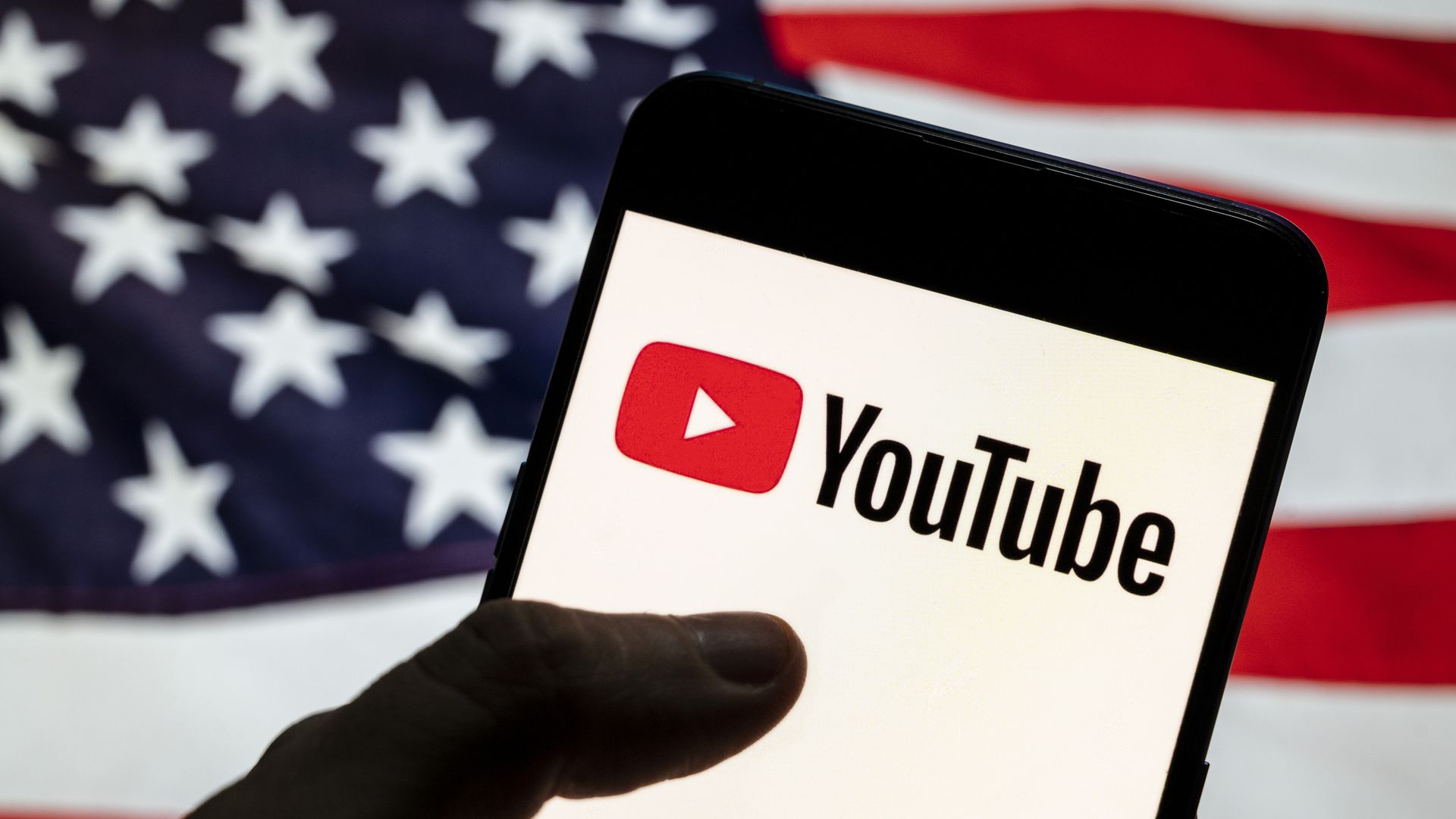 In this photo illustration the American video-sharing website Youtube logo is seen on an Android mobile device with the US flag.