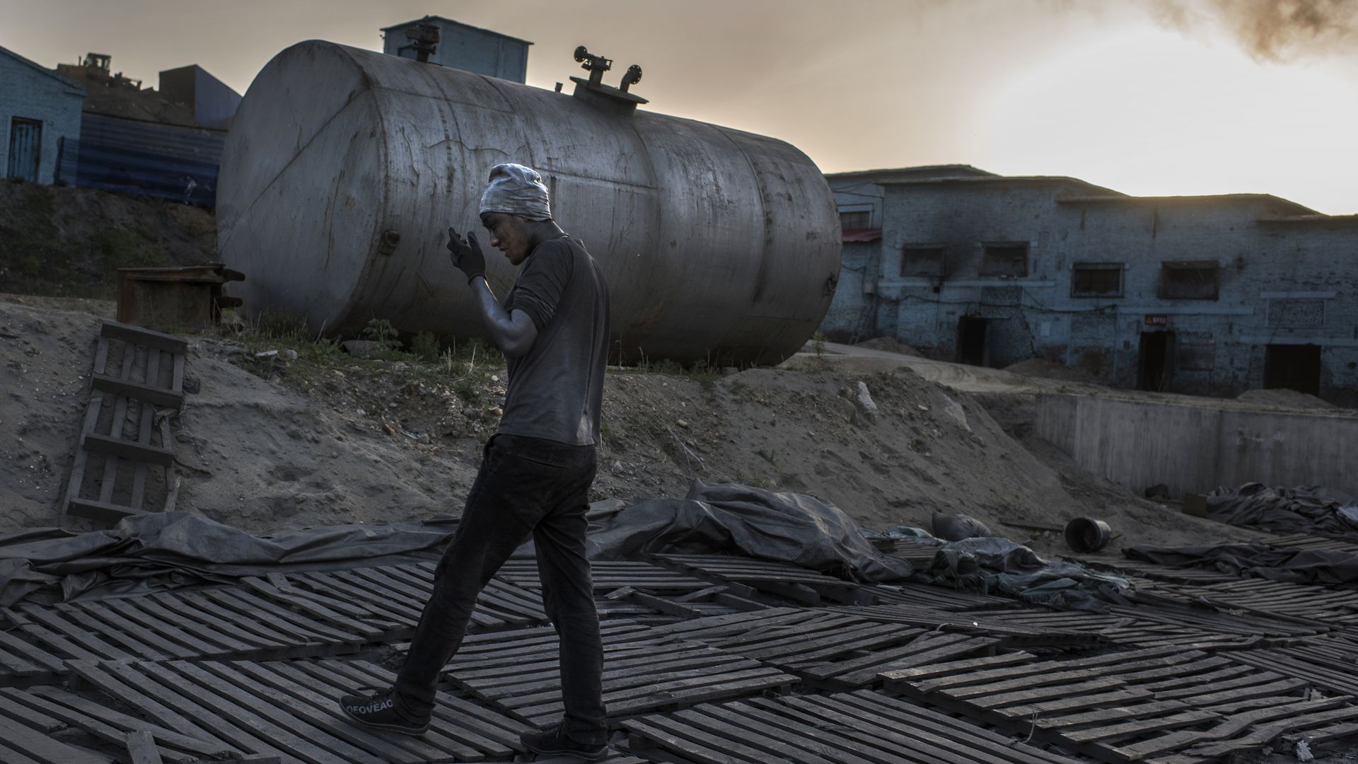 Photo of worker walking at a graphite factory in China