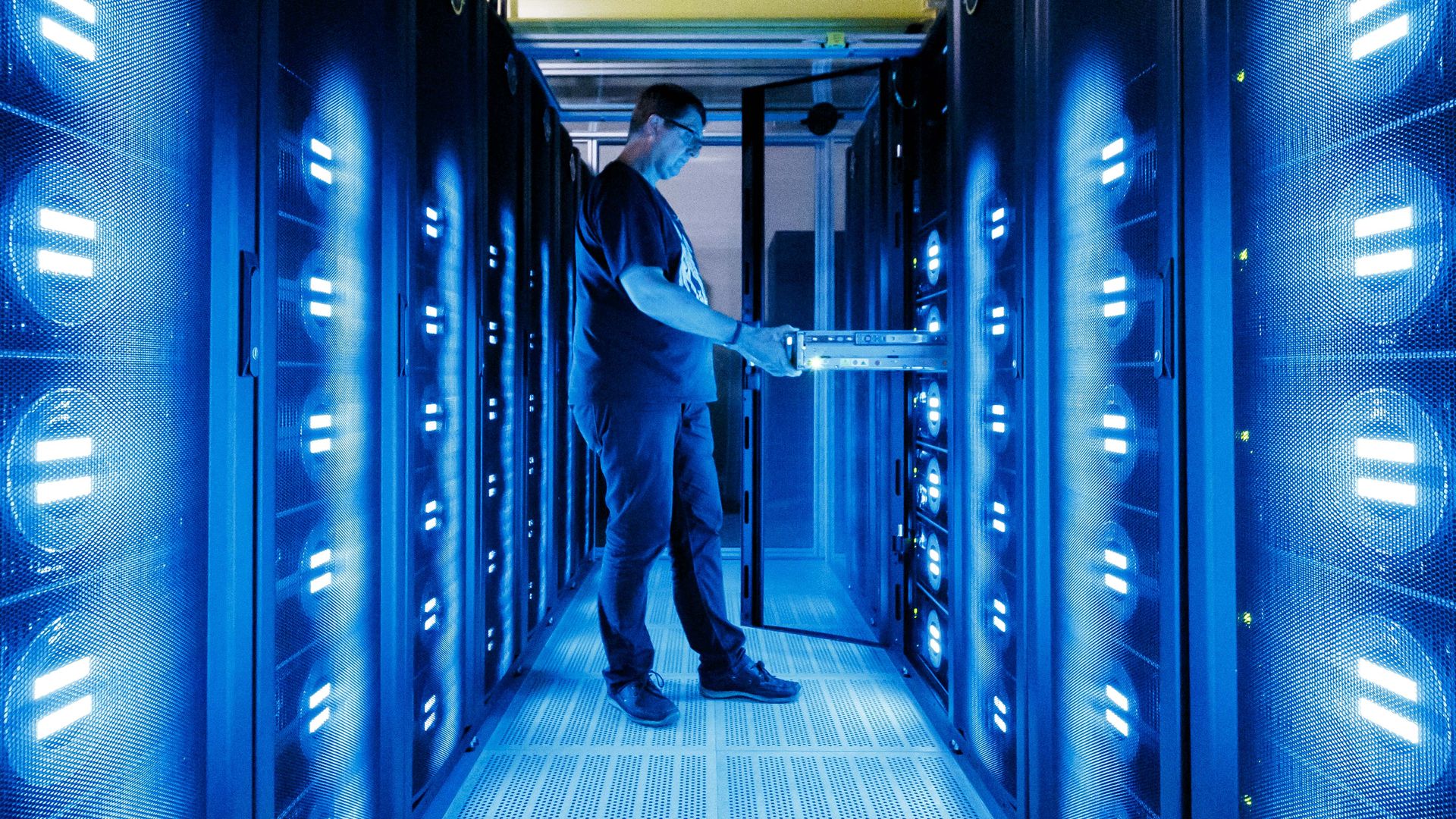 An employee of the German Climate Computing Center stands by the 'MistralÓ supercomputer in 2017.