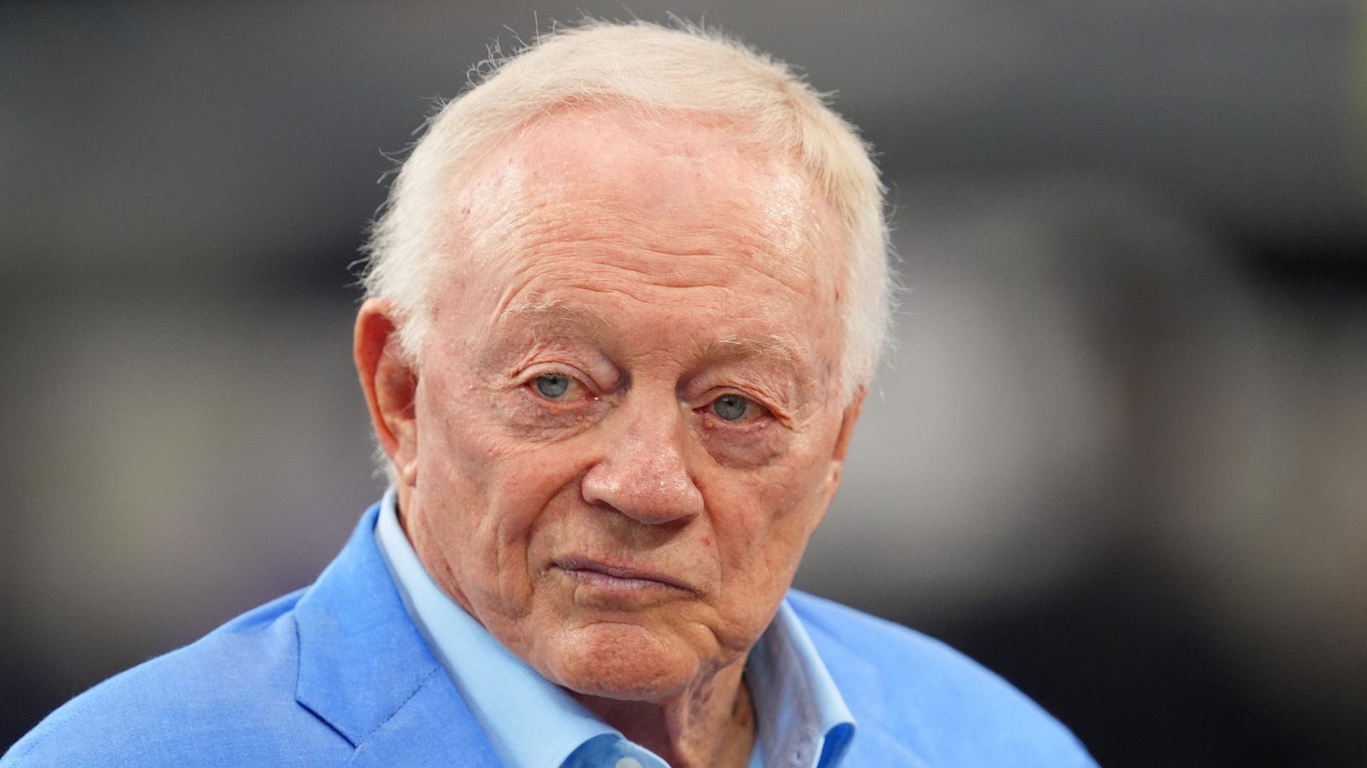 A man in a blue suit looking to the left