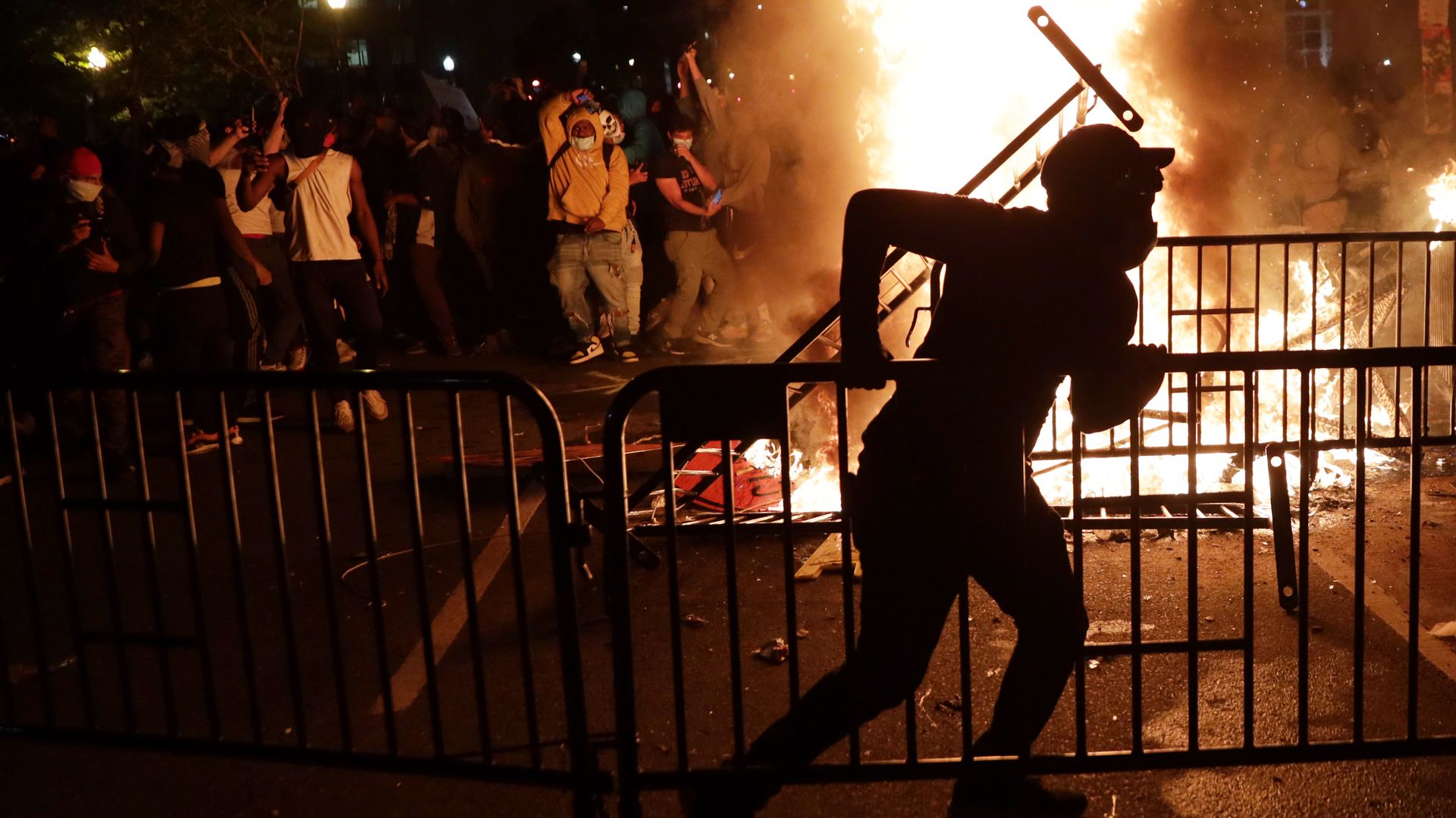 Demonstrators stand around a fire during a protest near the White House in response to the killing of George Floyd
