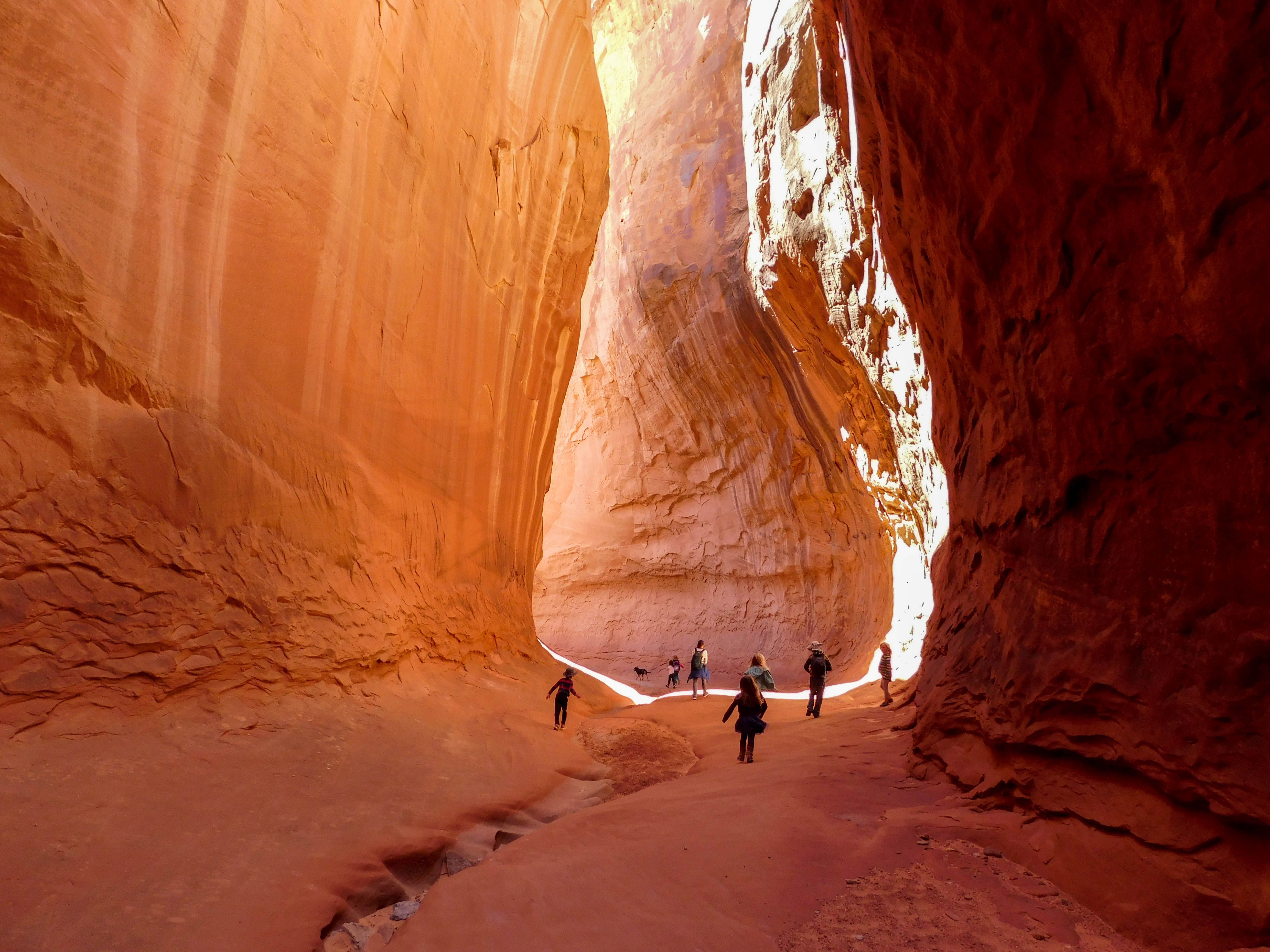 Children run through a red rock canyon. 