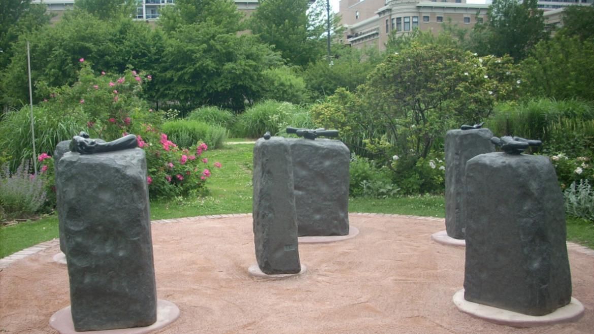 The "Helping Hands" statue of six gray slabs of rock with sculpted hands on each.
