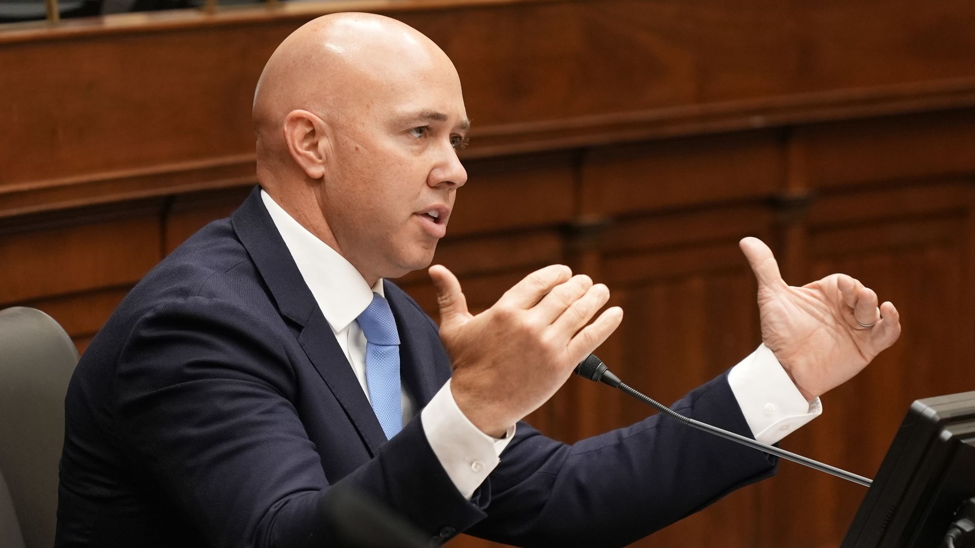 Brian Mast gestures while wearing a suit