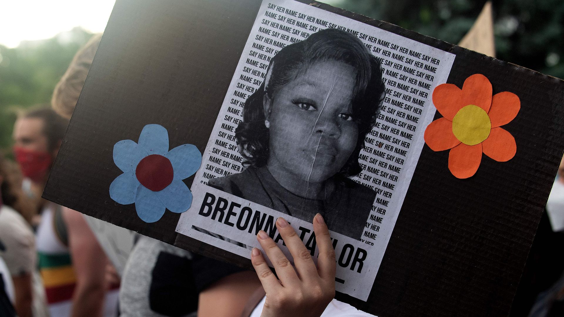 A demonstrator holds a sign with the image of Breonna Taylor, a black woman who was fatally shot by Louisville Metro Police Department officers, during a protest