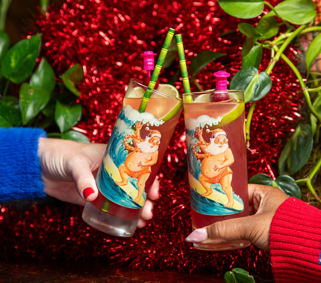Two glasses with images of surfing Santas.
