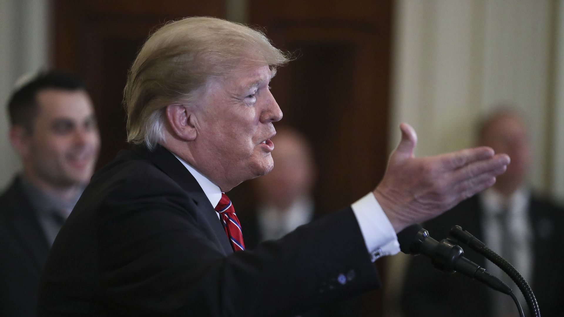 Donald Trump speaking and holding his right hand out toward the audience 