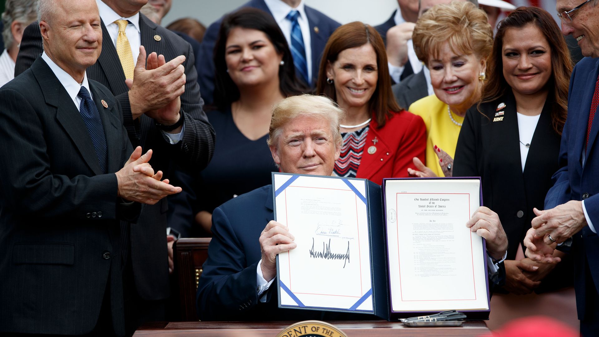 Trump holds up a signed VA mission act bill