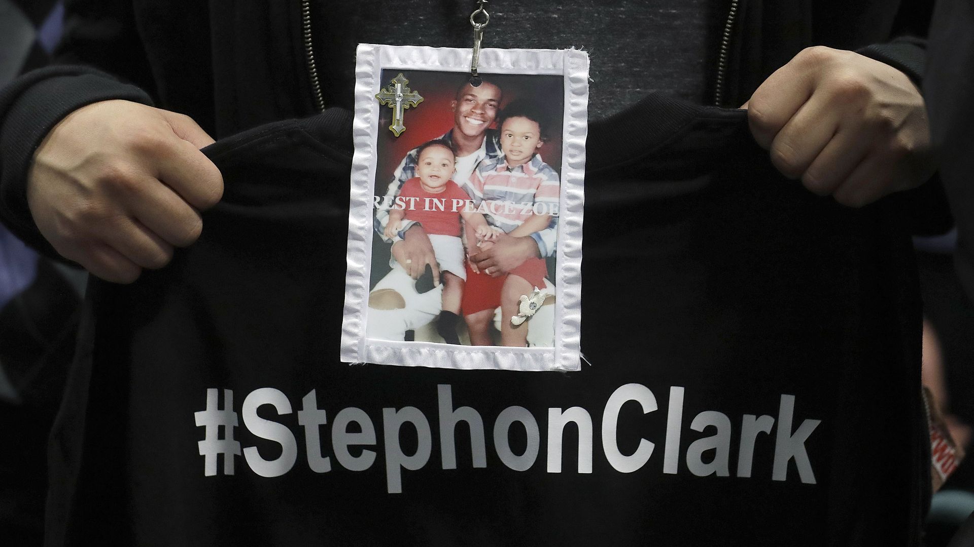 A mourner holds a photo of police shooting victim Stephon Clark. 