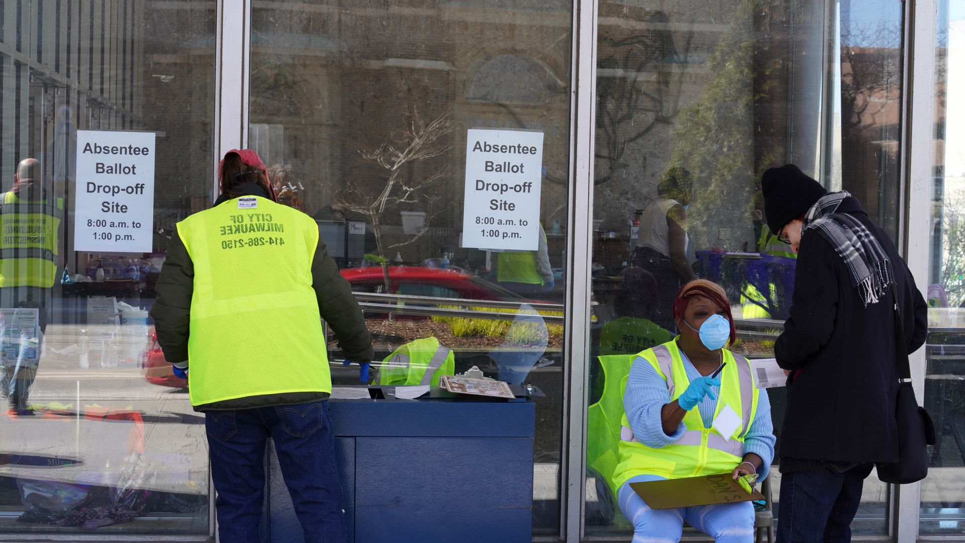 Picture of a ballot drop-off location with people outside receiving ballots