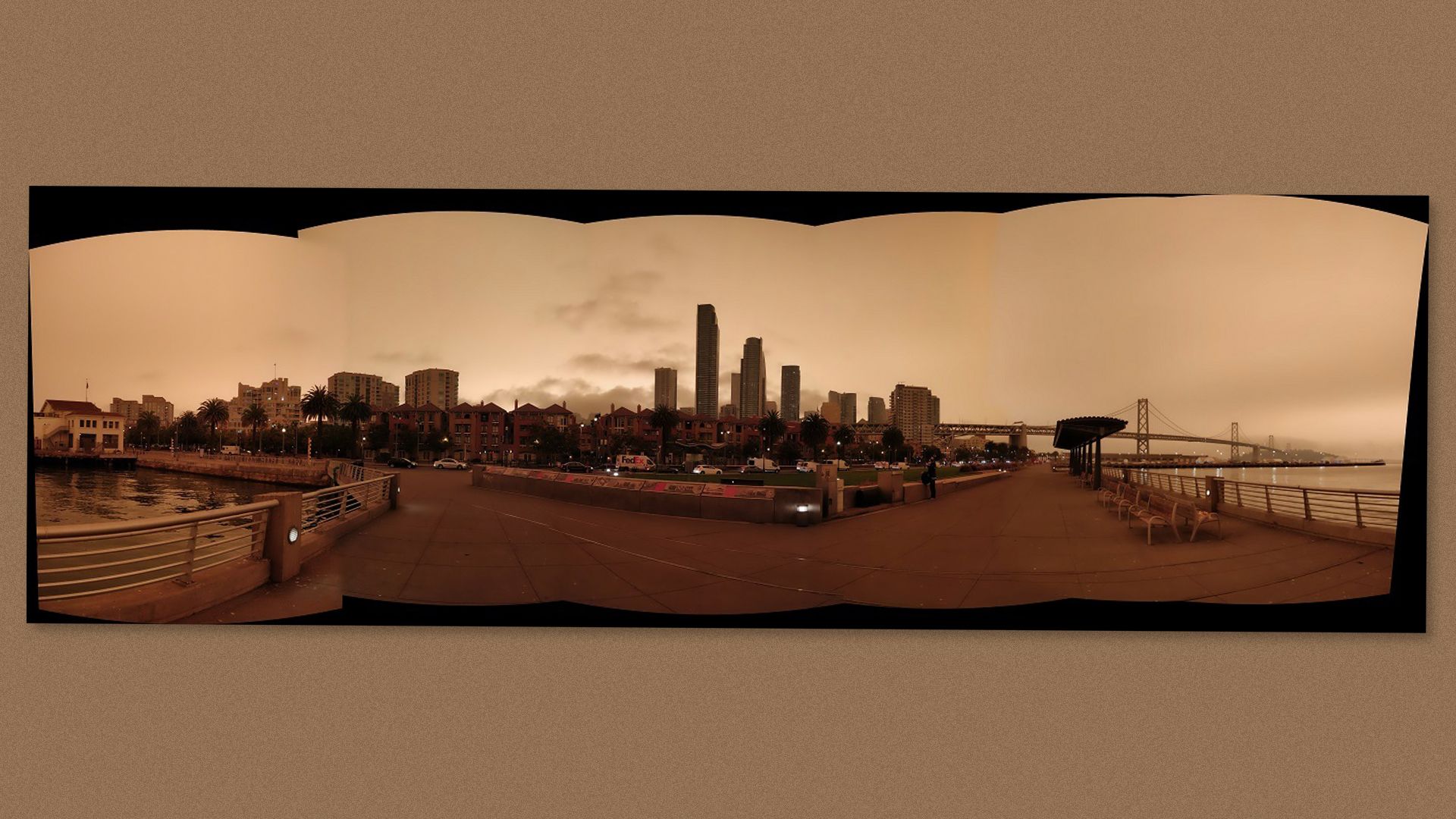 A panoramic view of orange skies over a San Francisco wharf.