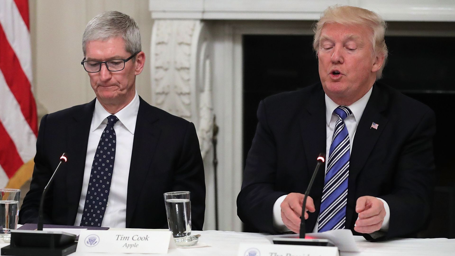 In this image, Tim Cook and Trump sit next to each other at a long table in the White House, both wearing suits.