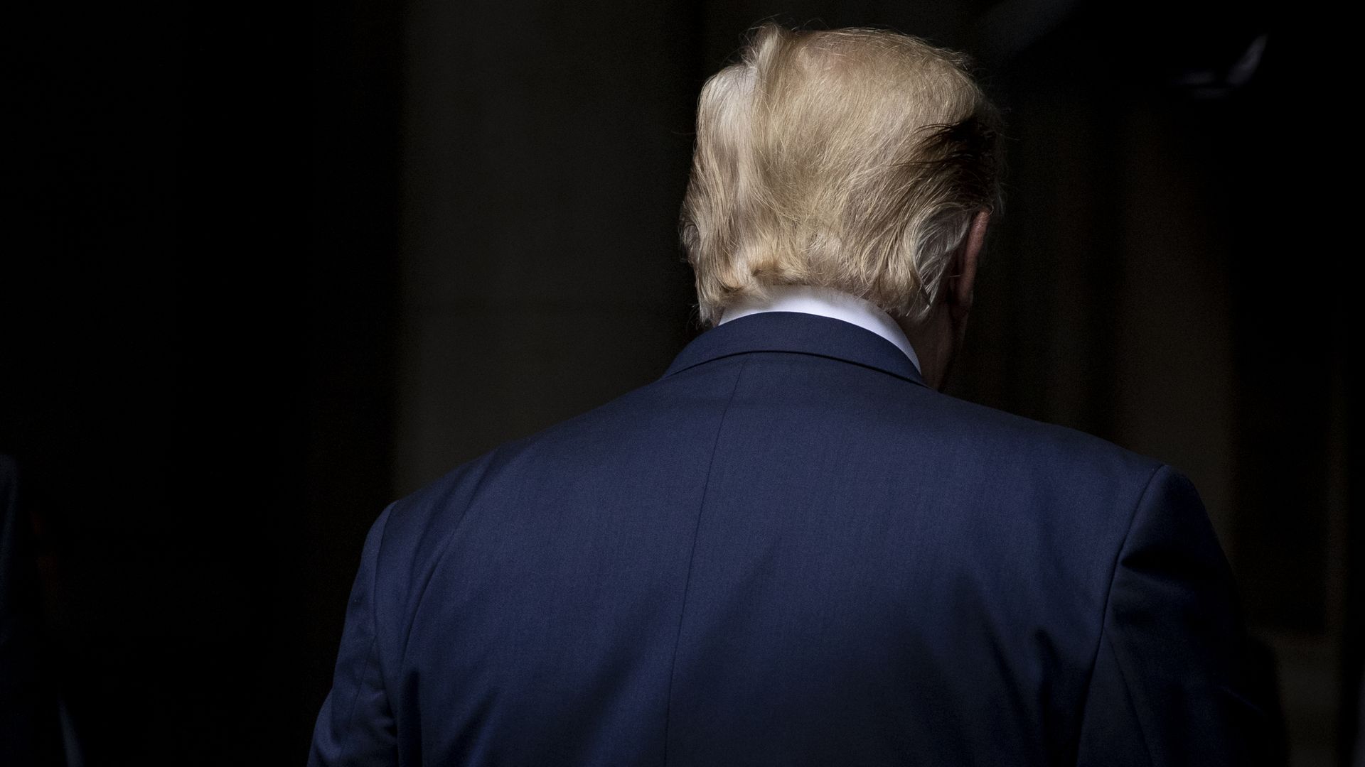 This image shows the back of Trump's head. He's wearing a suit.