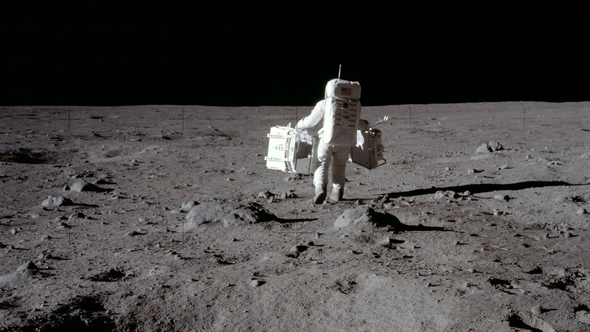 An Apollo astronaut with his back to the camera on the moon.