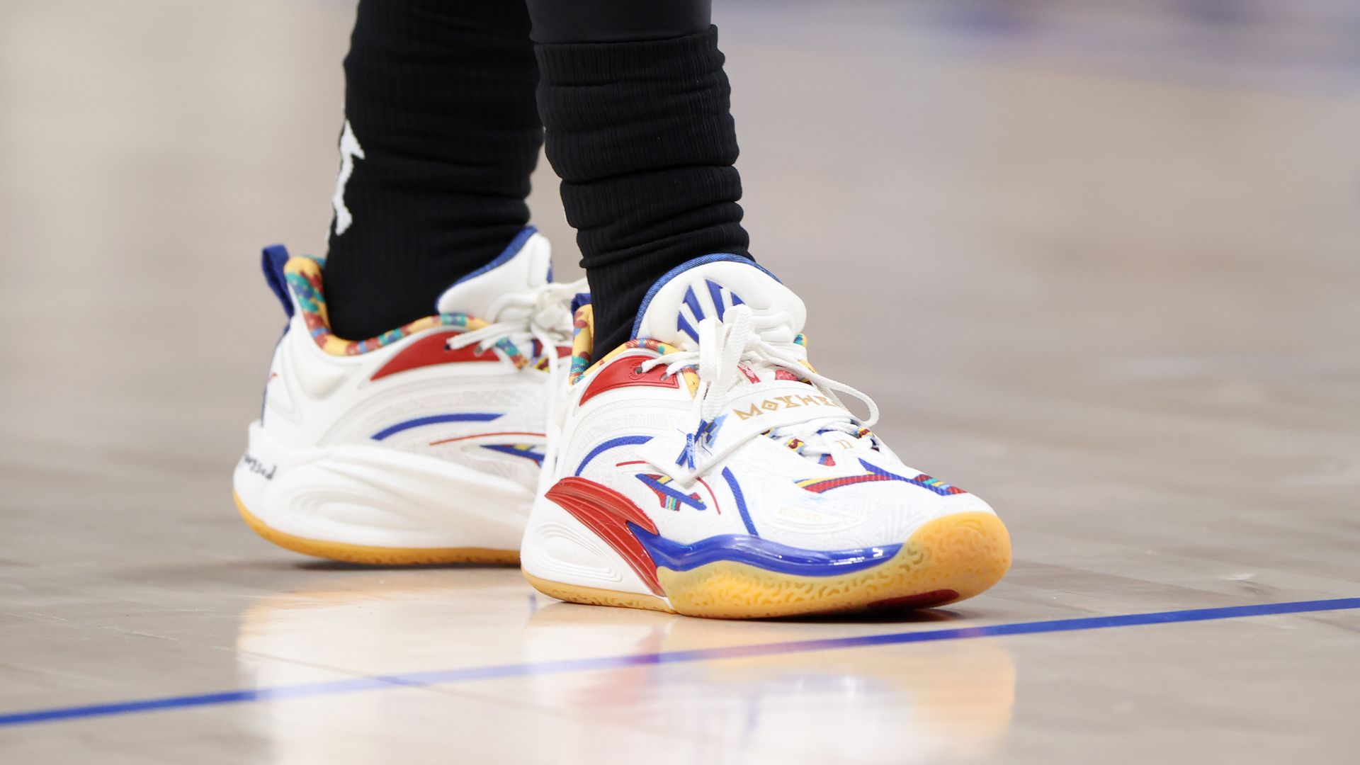 A close up shot of white shoes with yellow and red accents