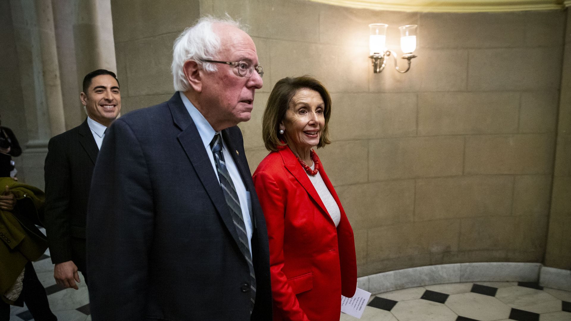 Sen. Bernie Sanders walks alongside Rep. Nancy Pelosi.
