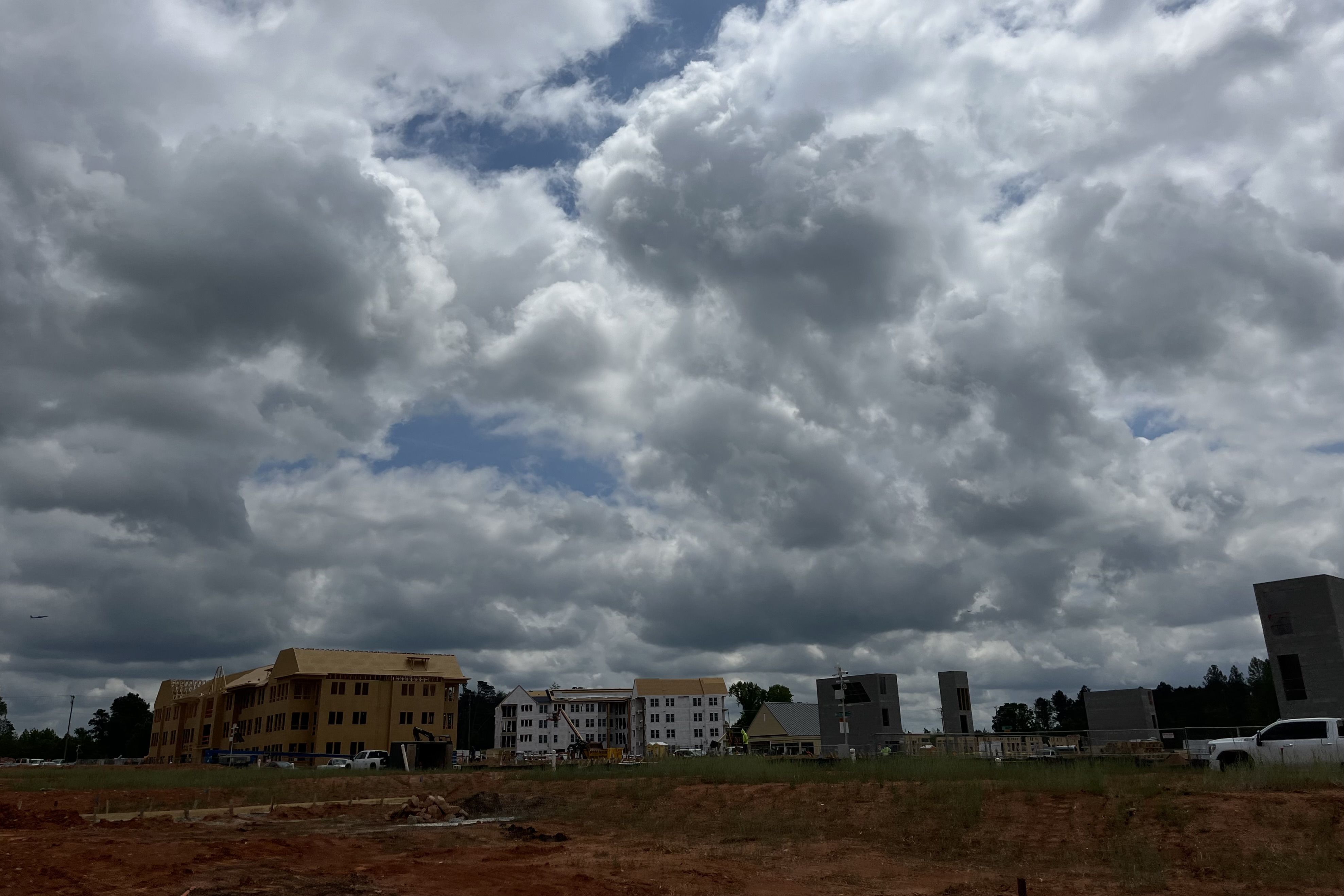 Construction off in the distance with a dirt lot in the forefront