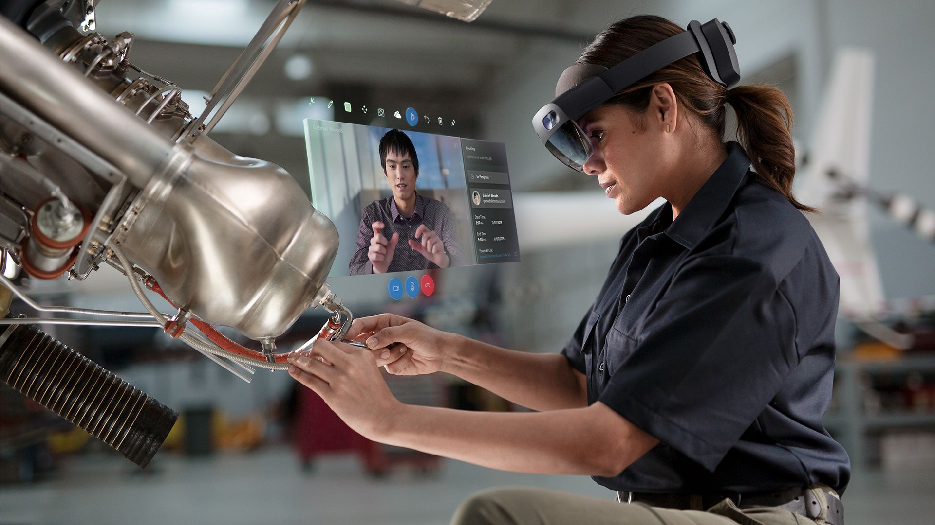 A woman uses Microsoft's HoloLens 2 to fix a machine