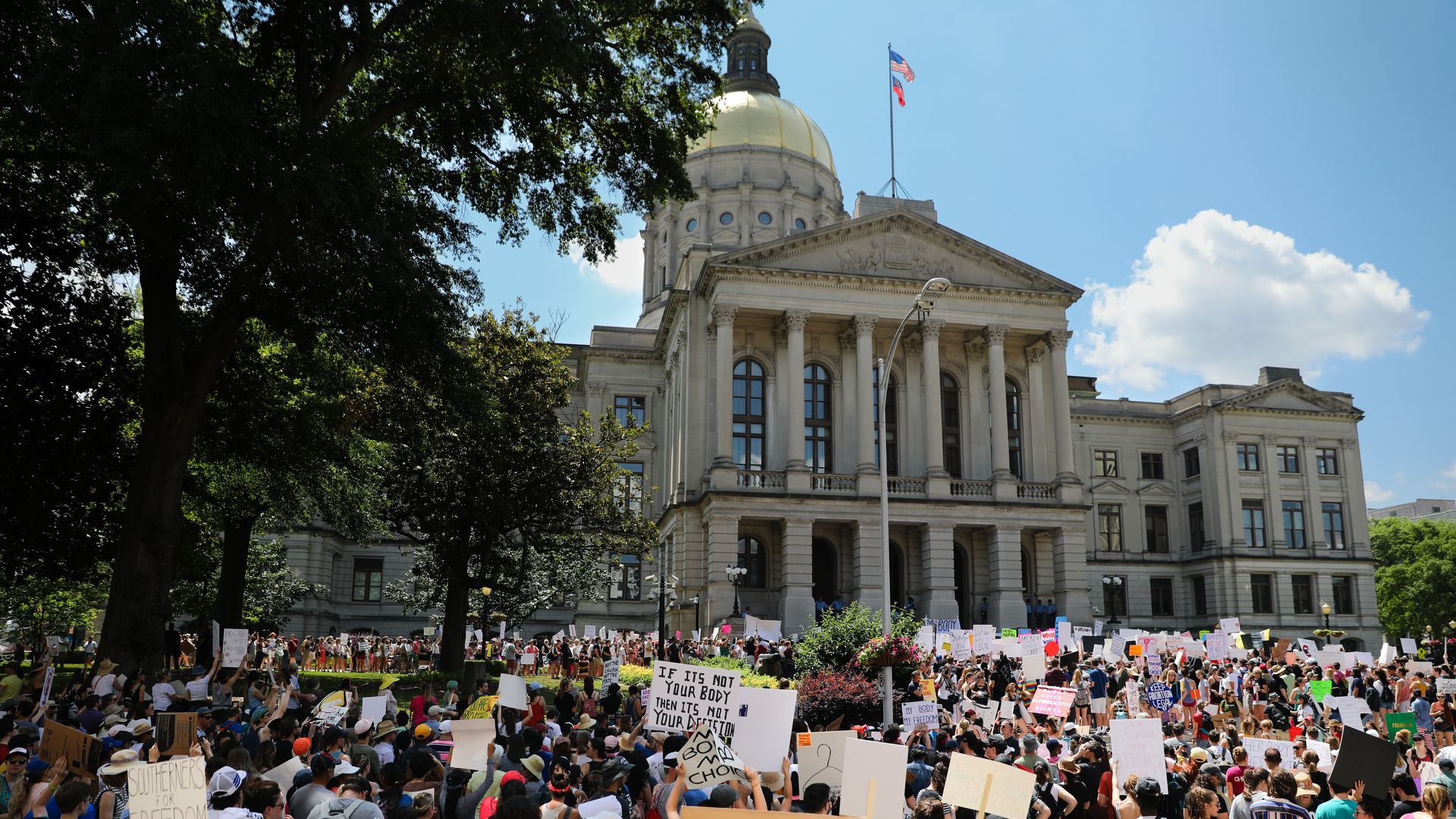Demonstrators hold signs during a protest against Georgia's "heartbeat" abortion bill outside of the Georgia State Capitol building in Atlanta, Georgia, U.S., on Saturday, May 25, 2019. 