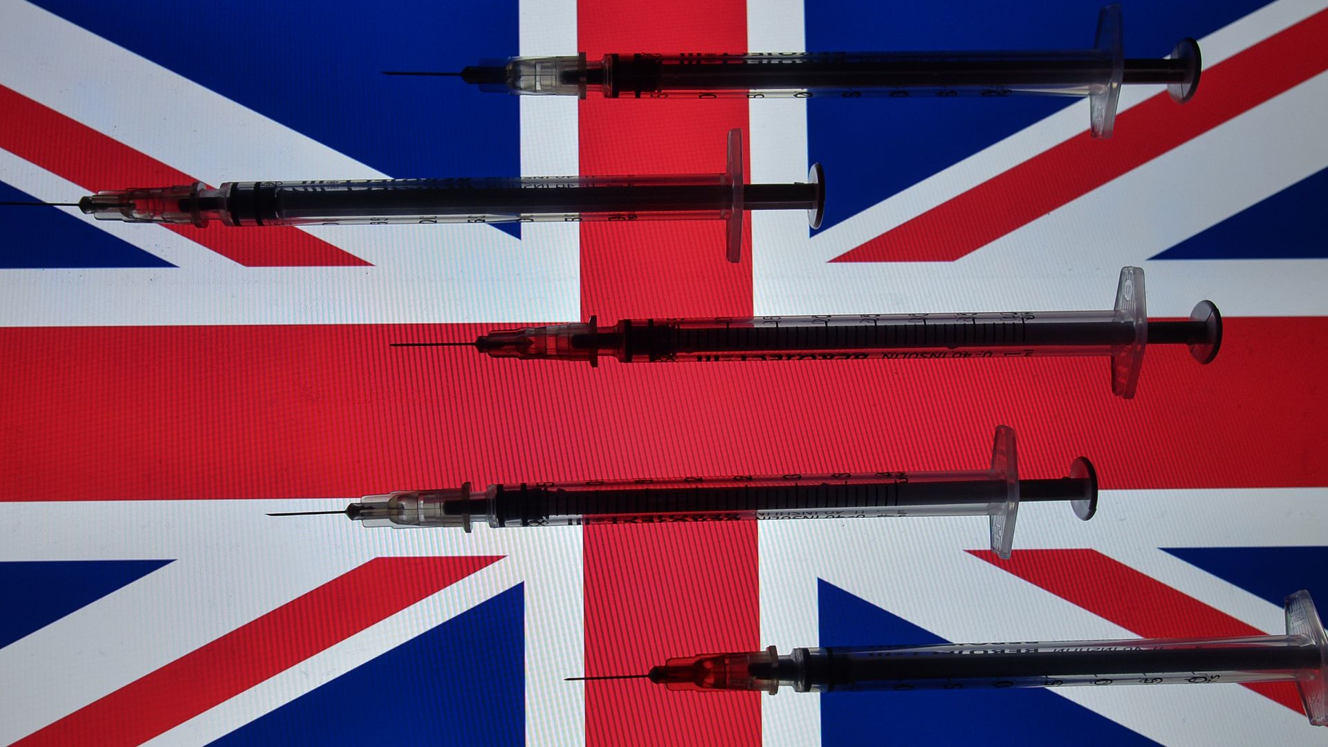 Picture of syringes in front of a British flag