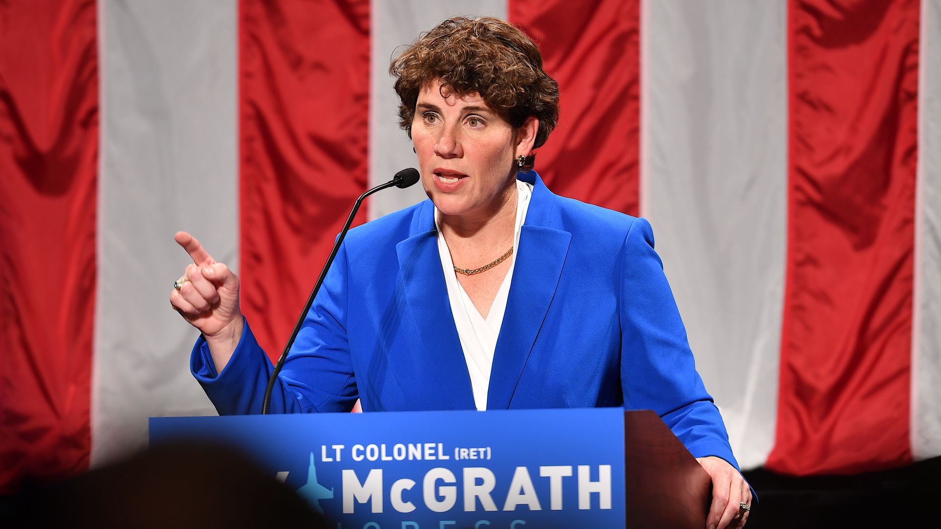 Amy McGrath talks in front of a podium.