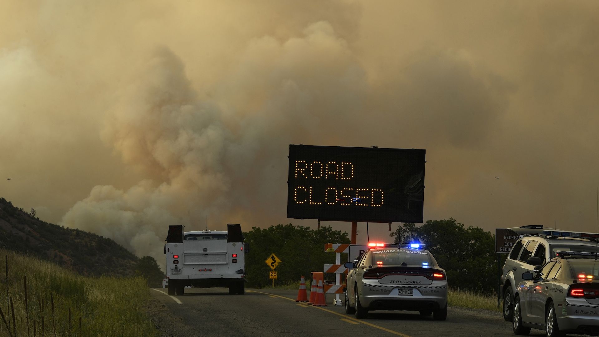 Smoke billows from the 416 fire along a closed road in Colorado.