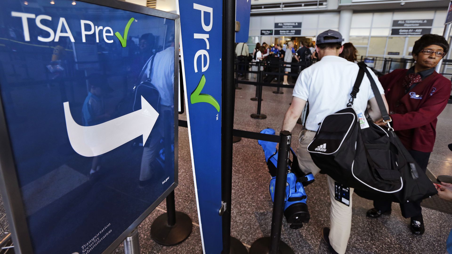 A passenger passes by a sign for the Transportation Security Administration's TSA Precheck line in Boston Logan.