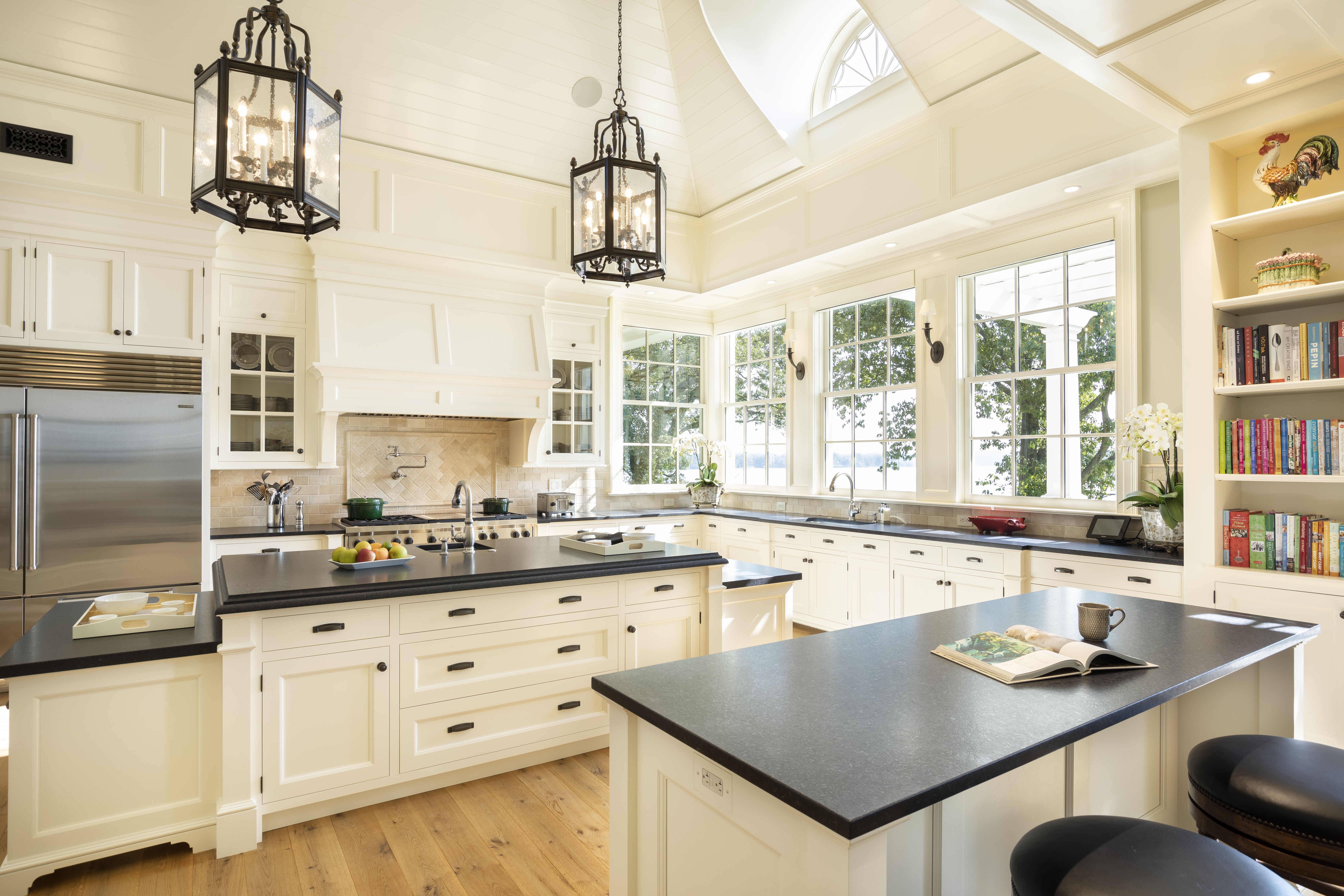 A white kitchen with windows overlooking the Potomac River. 