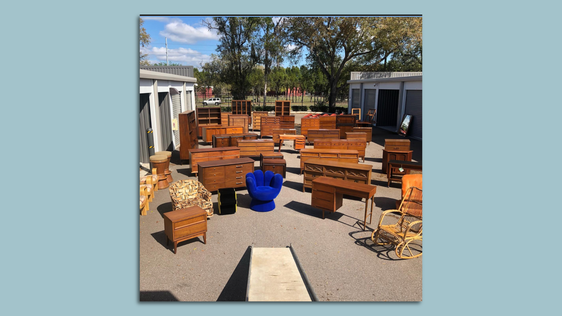 A photo of a large collection of mid-century modern furniture outside storage units