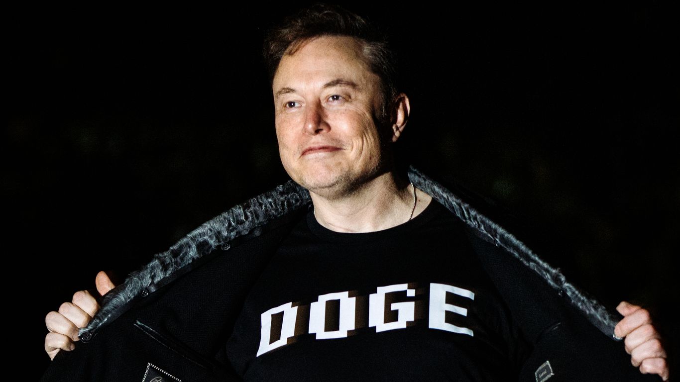 Elon Musk photographed wearing a black shirt that reads "DOGE" in white letters. 