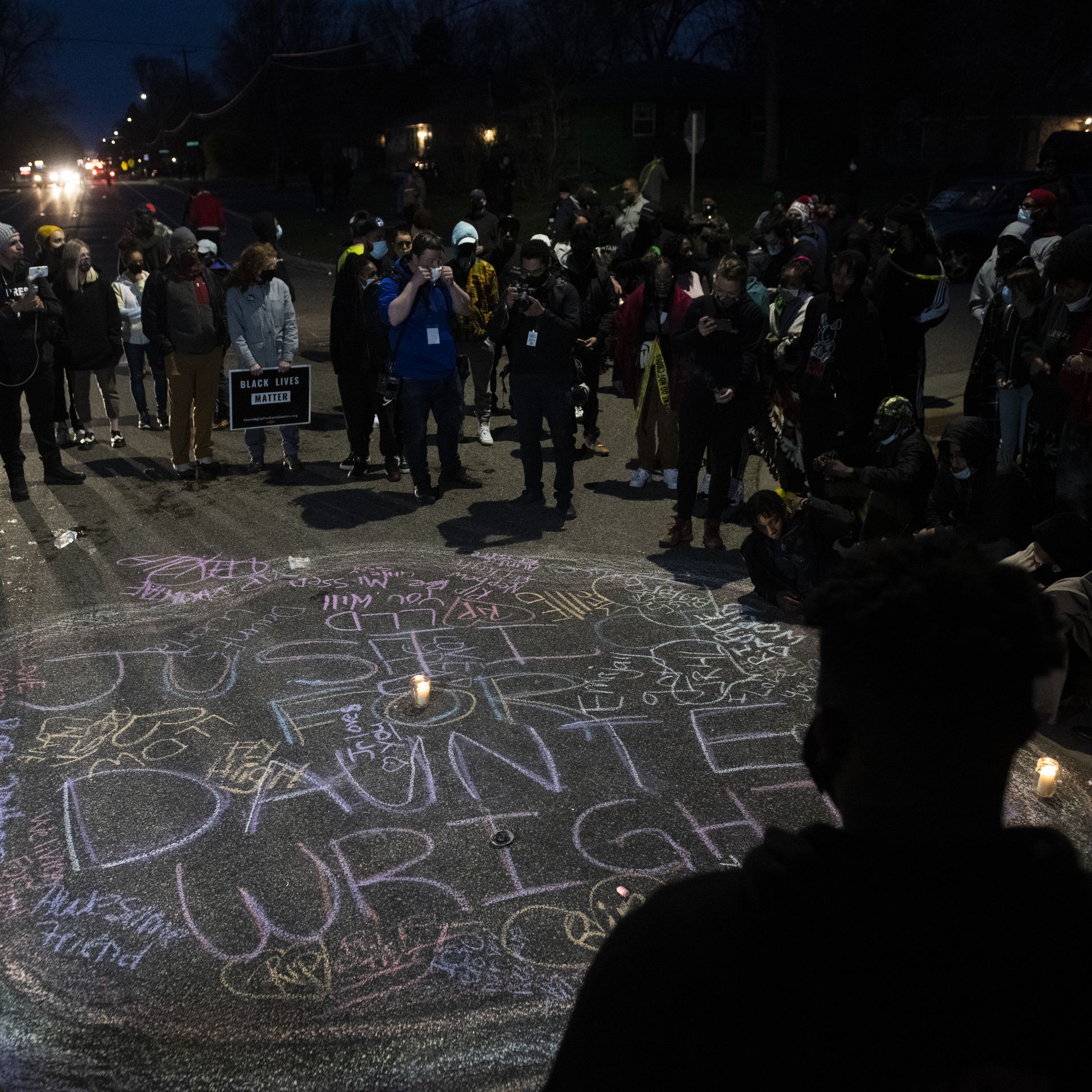 Protesters create a chalk circle that reads "Justice for Daunte Wright" in the street on April 11, 2021 in Brooklyn Center, Minnesota.
